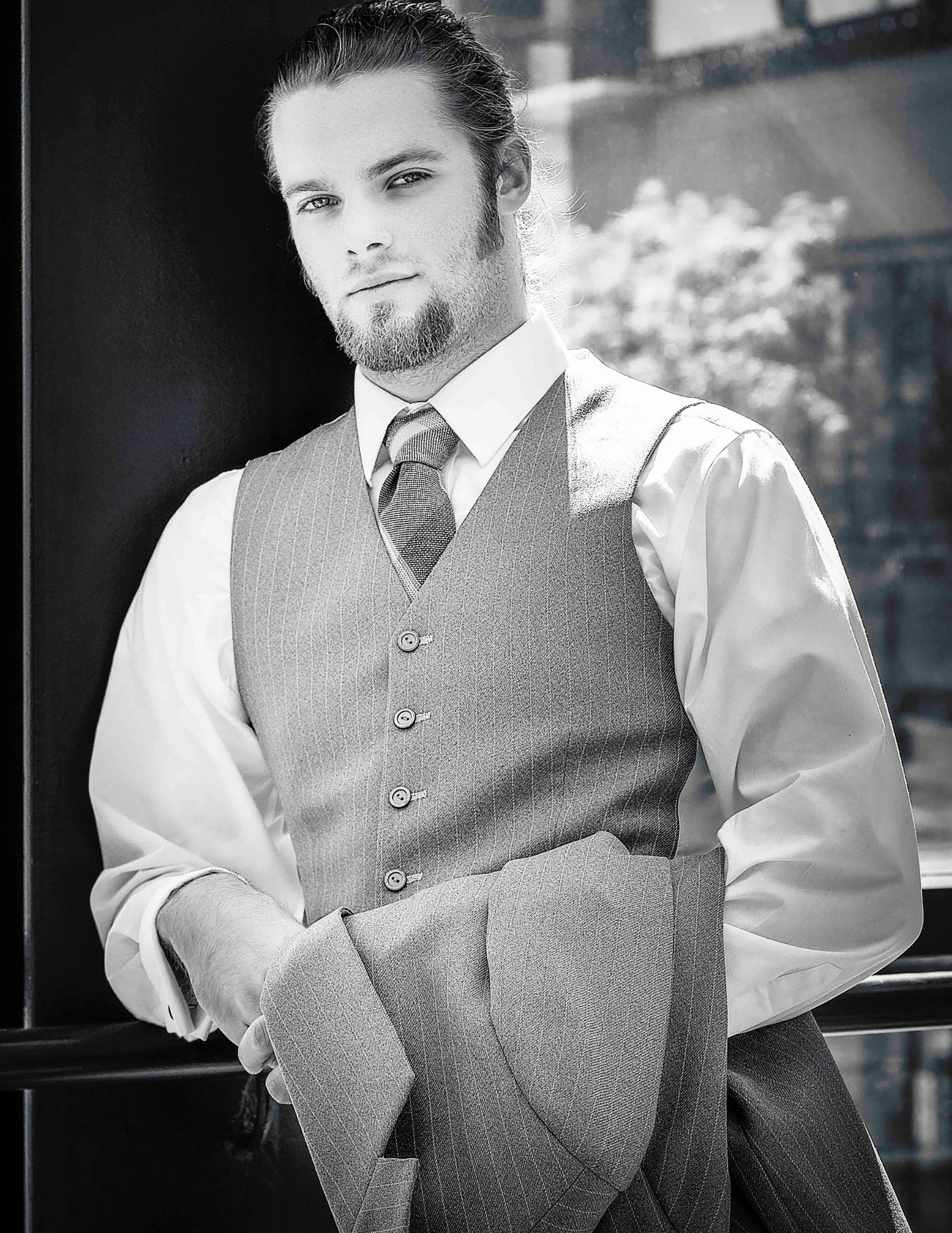 Black-and-white portrait of a man wearing a vest and tie