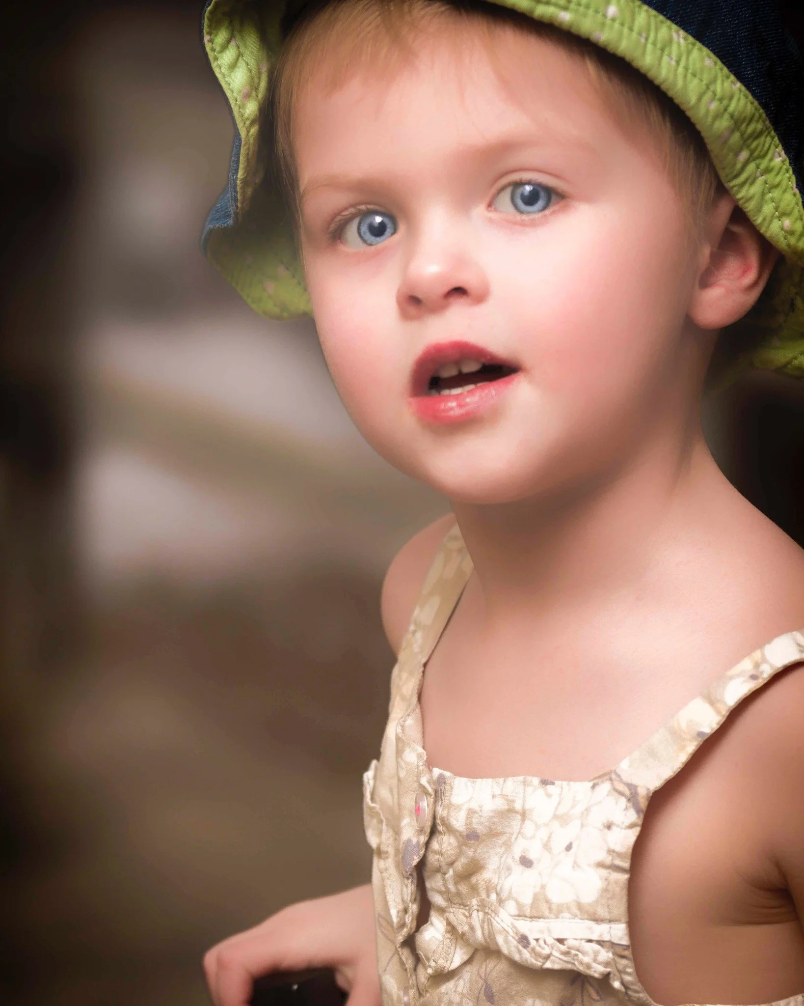 Close-up portrait of a young child wearing a sun hat