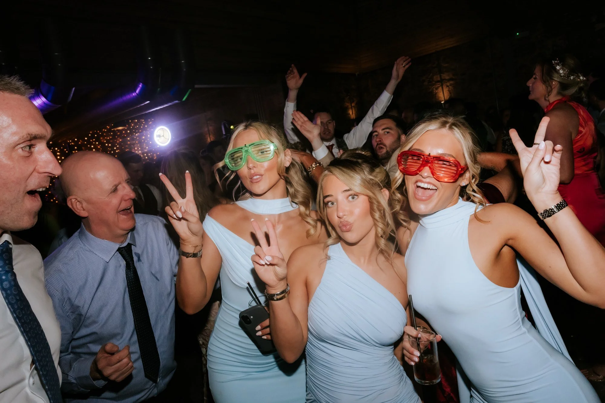 Wedding guests wearing novelty glasses on the dance floor