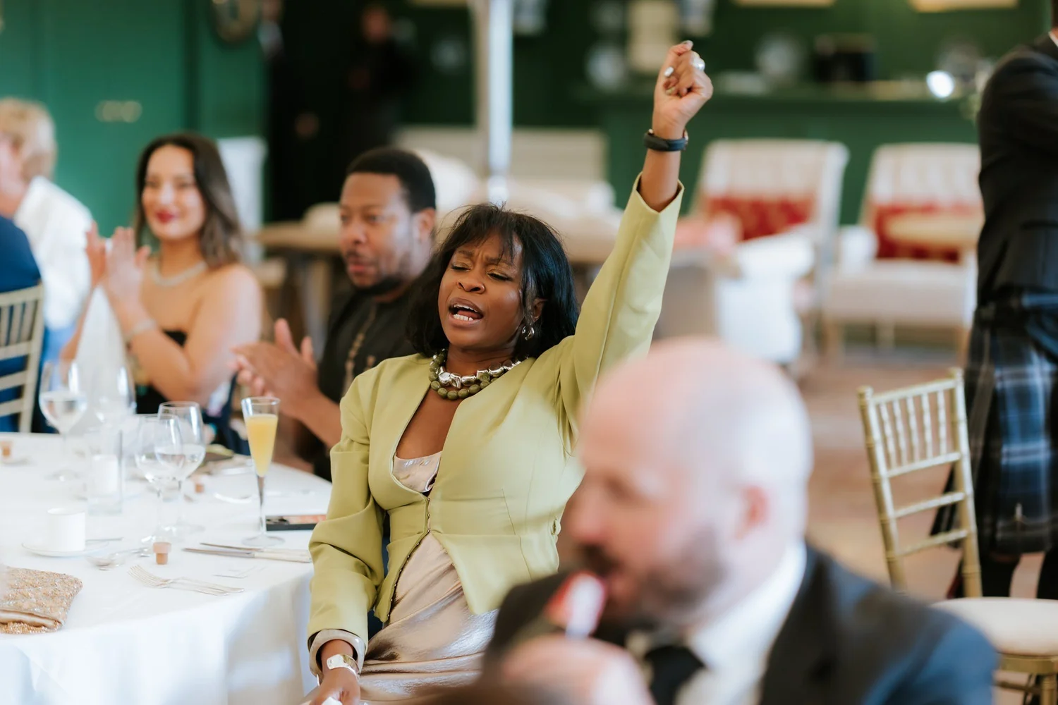 A wedding guest raising her arm during the reception celebrations.