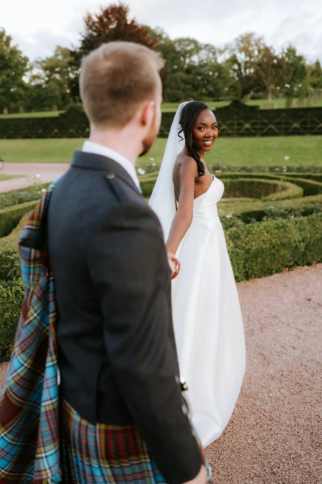 Kuda smiling back at Jamie as she leads him through the gardens.