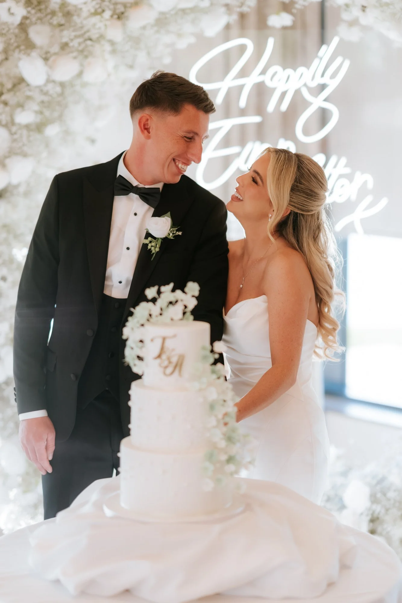 Aiden and Taylor standing together at their wedding cake.