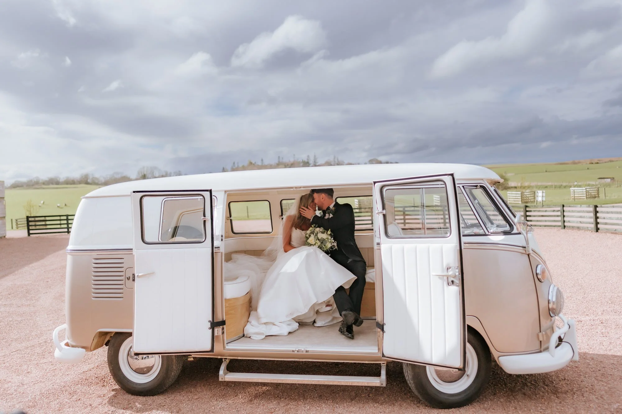 Natalie and Jamie kissing beside a camper van