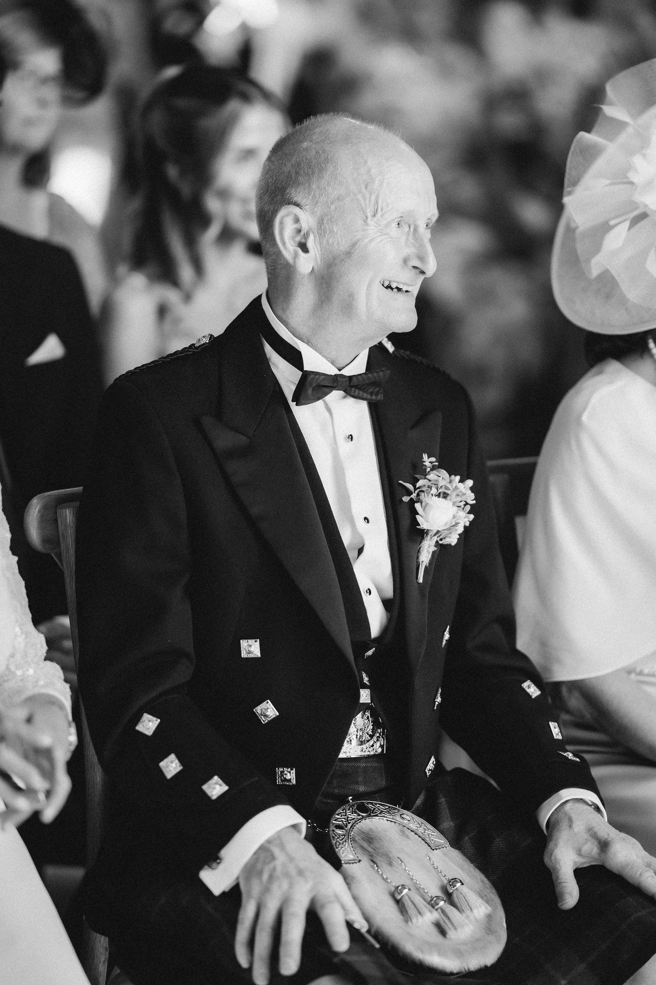Lilian’s dad smiling through an emotional moment in the ceremony, photographed in black and white.