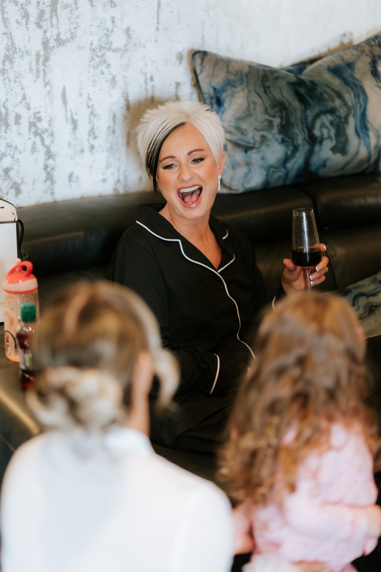 A woman laughing with children during the wedding morning