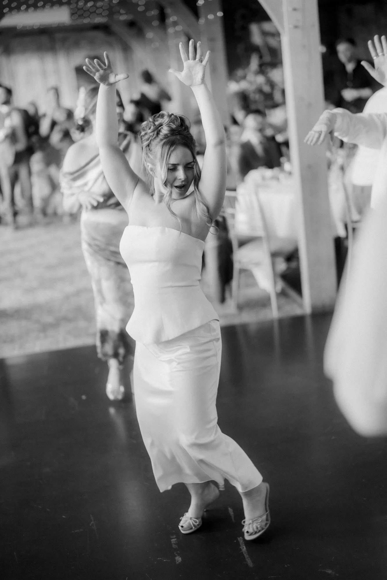 A guest dancing with her arms in the air.