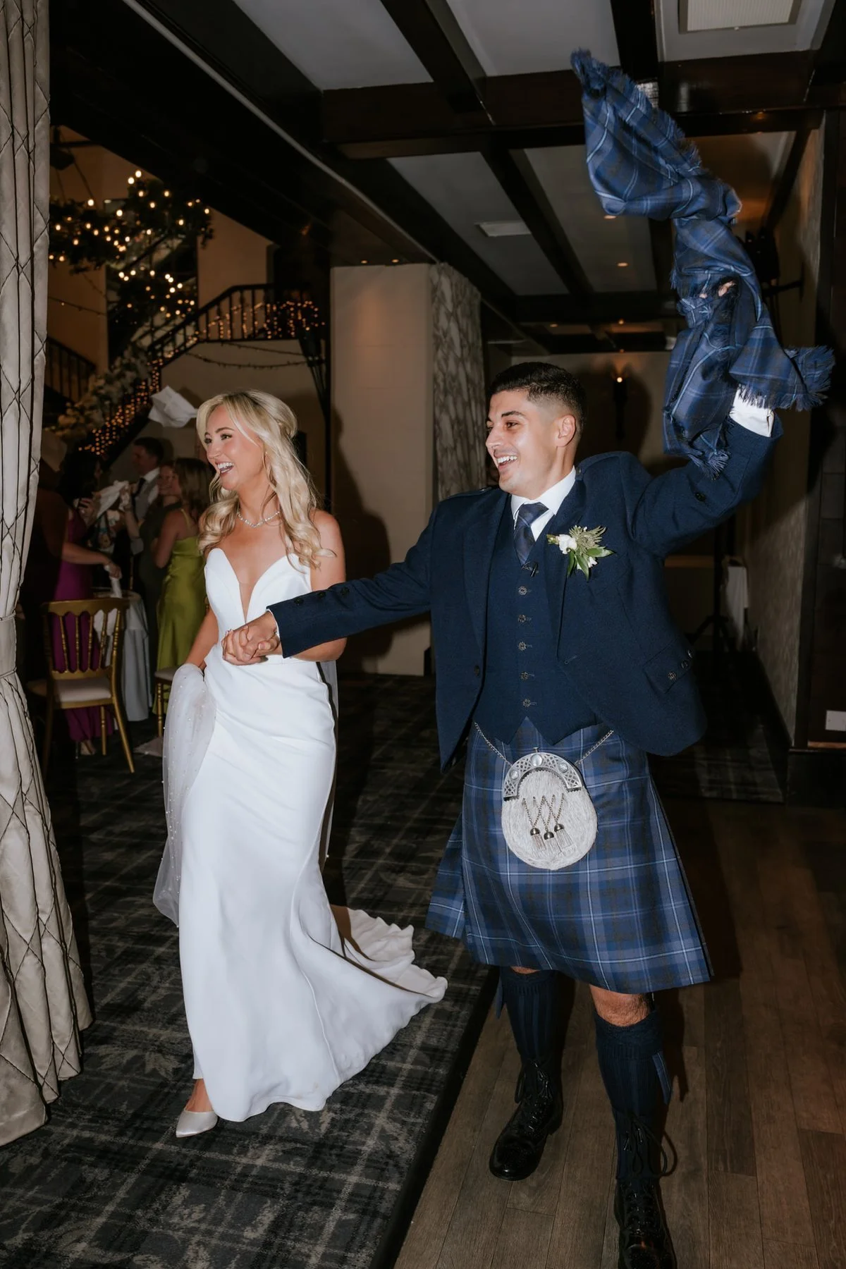 Lauren and Zen raising their arms as they make their entrance to the wedding breakfast.