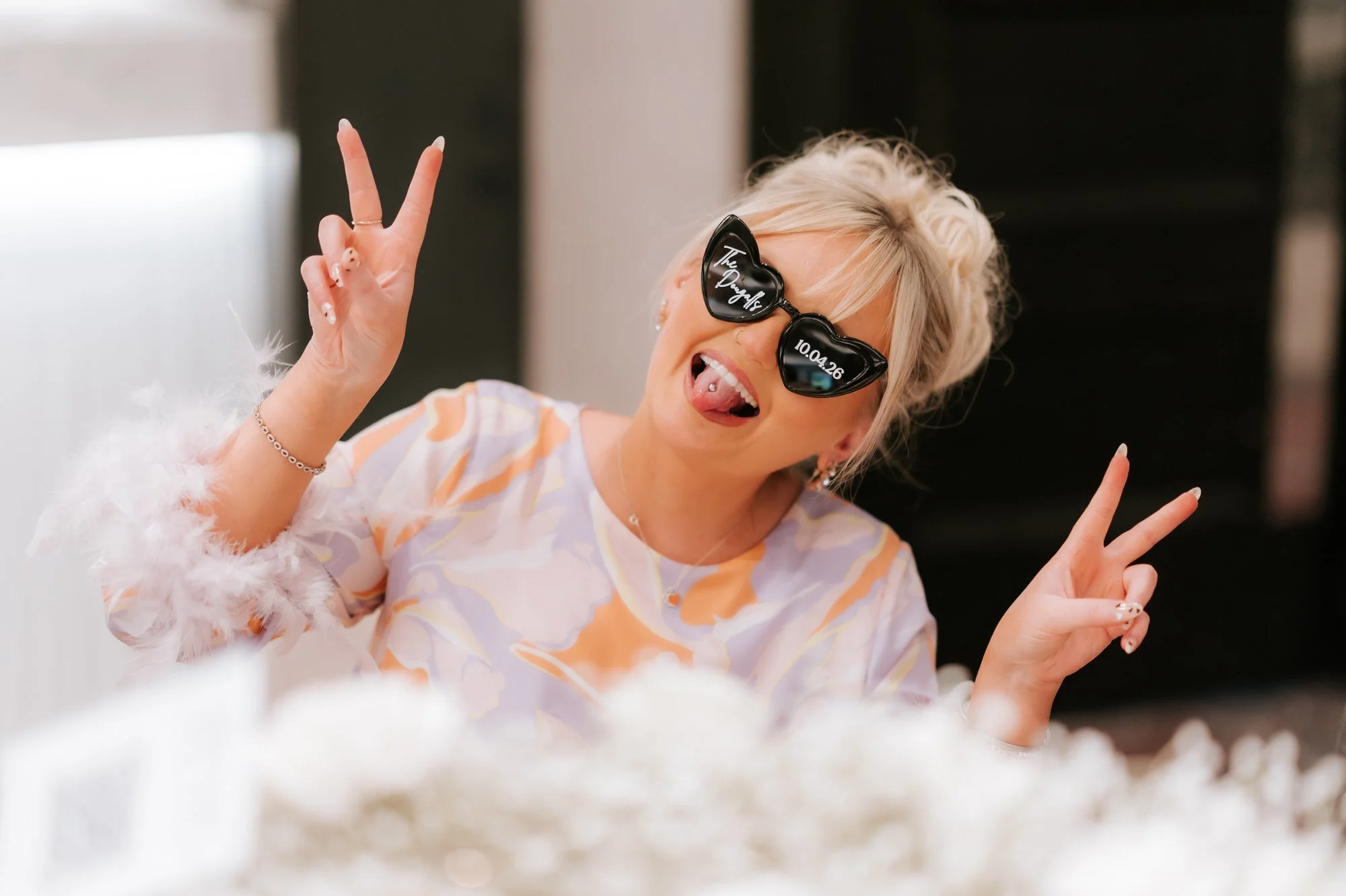 A guest in an orange and lilac dress making a peace sign