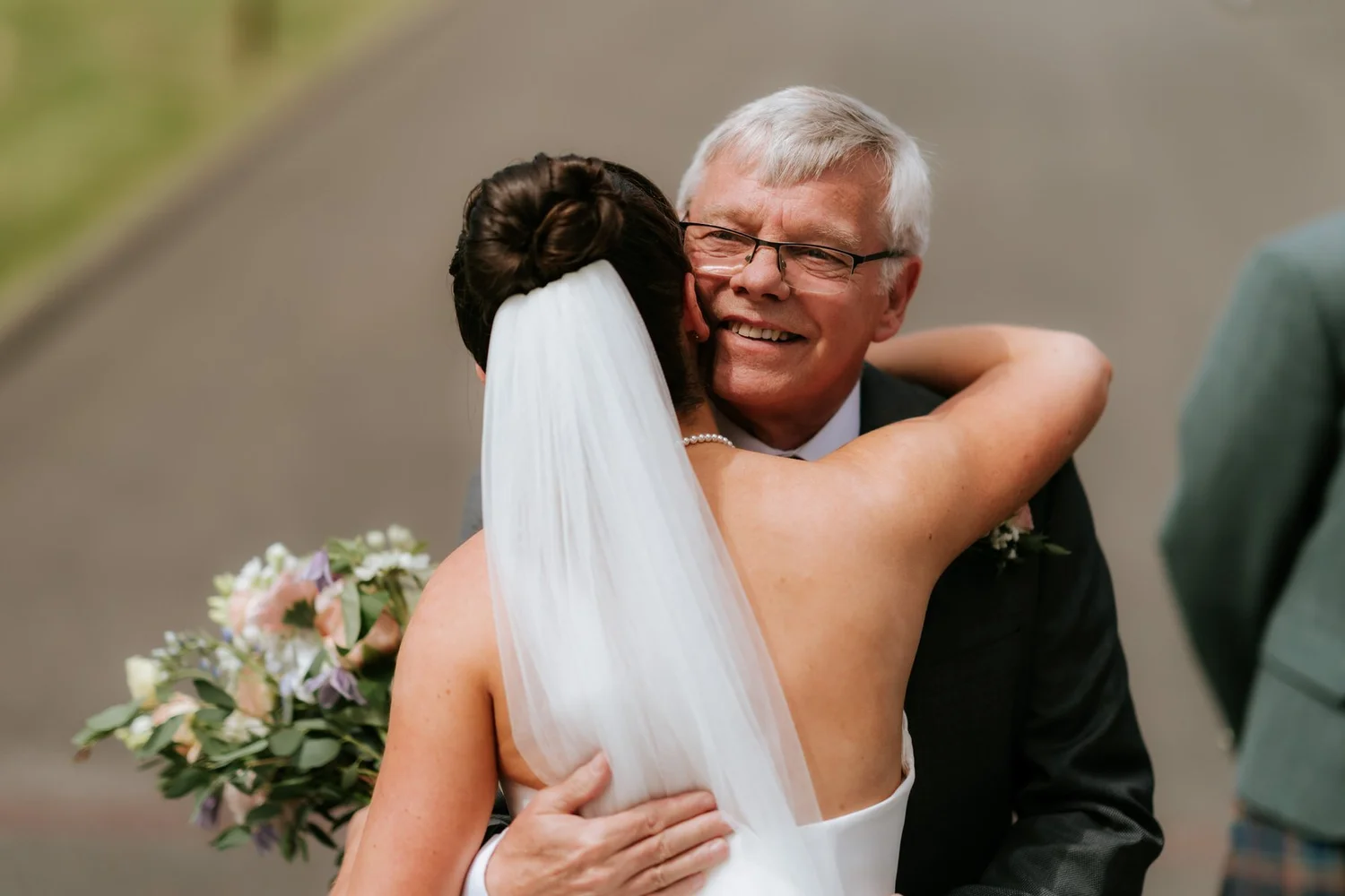 Lois hugging a smiling wedding guest during the drinks reception.