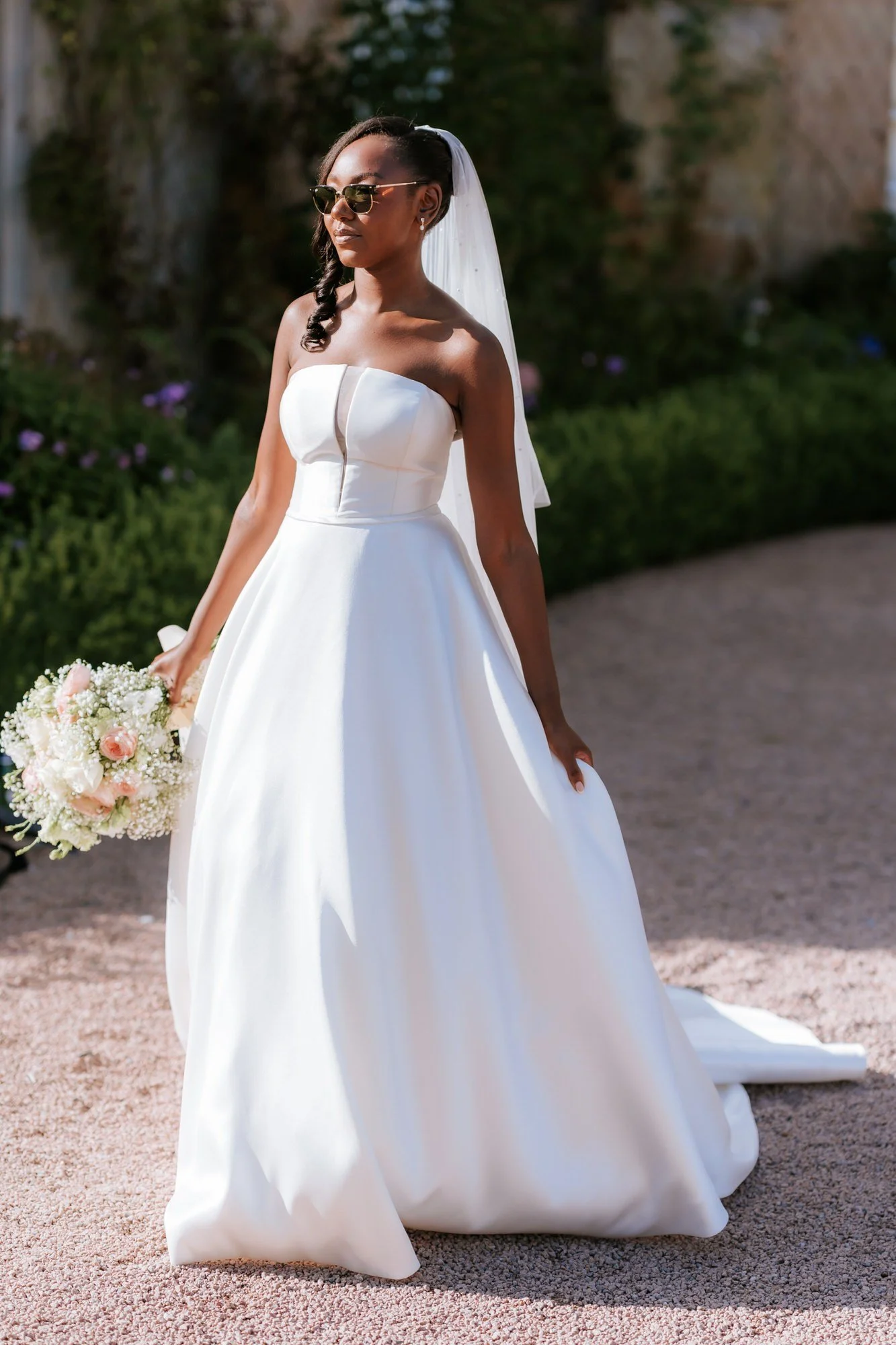 Kuda wearing sunglasses and holding her bouquet.