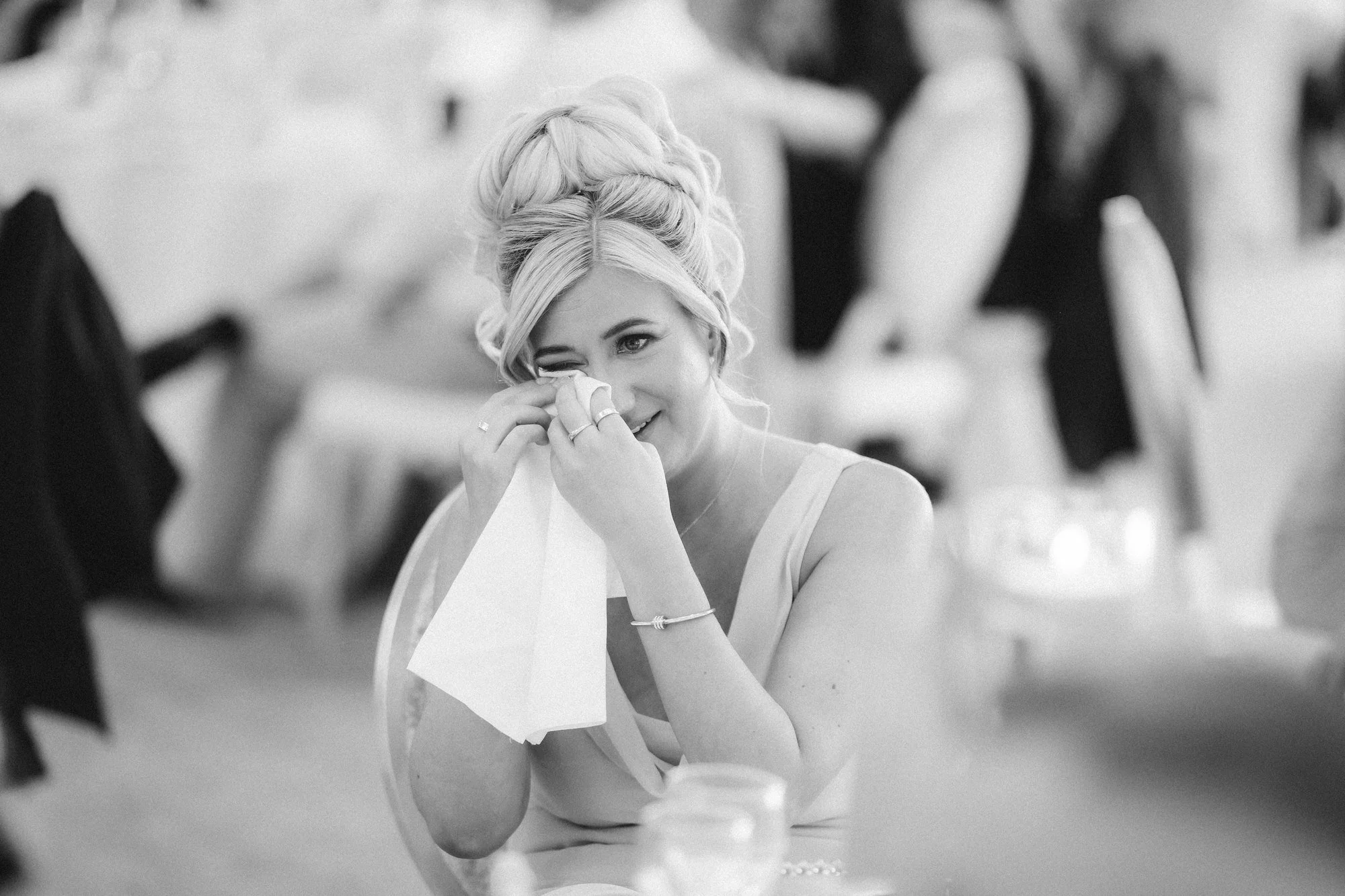 Taylor laughing into a napkin during the wedding speeches.