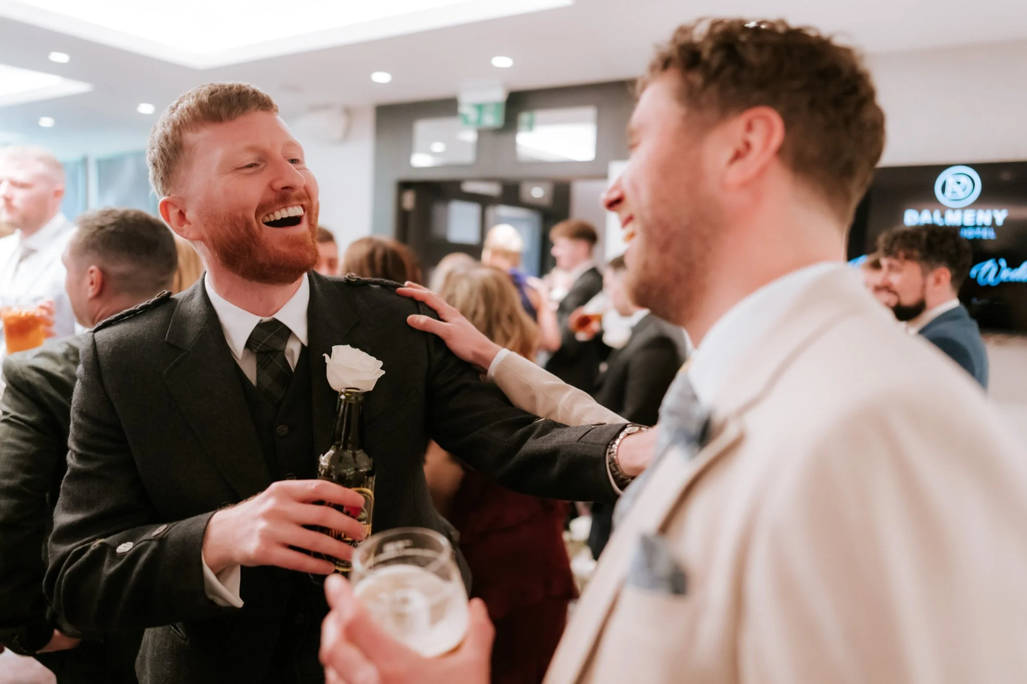 Groomsmen laughing together during the drinks reception