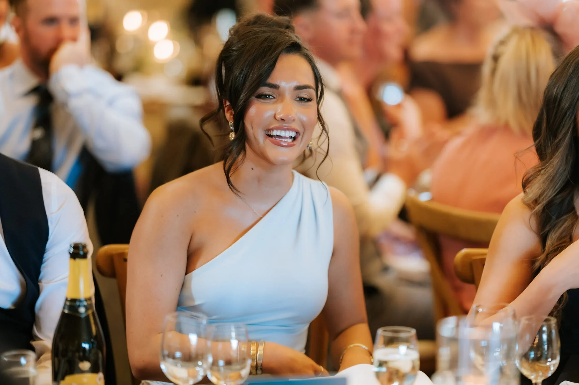 A guest in blue laughing during the speeches