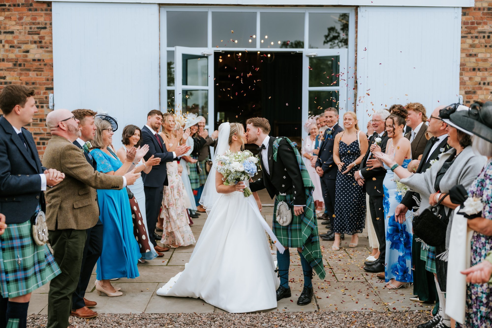 Guests showering Lilian and Luke with confetti outside the byre at Rossie on the Earn.