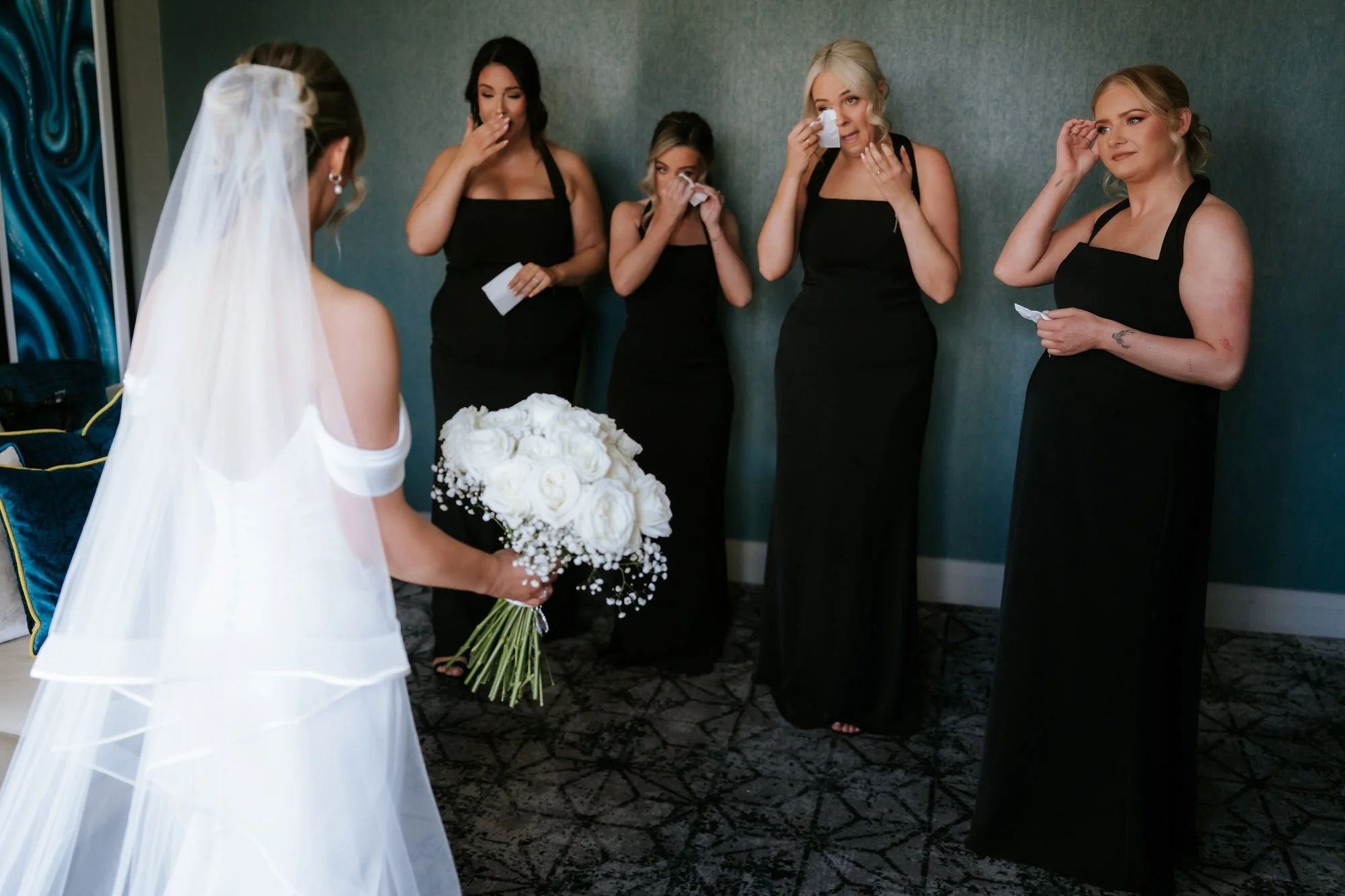 Bridesmaids reacting emotionally to Elle in her wedding dress
