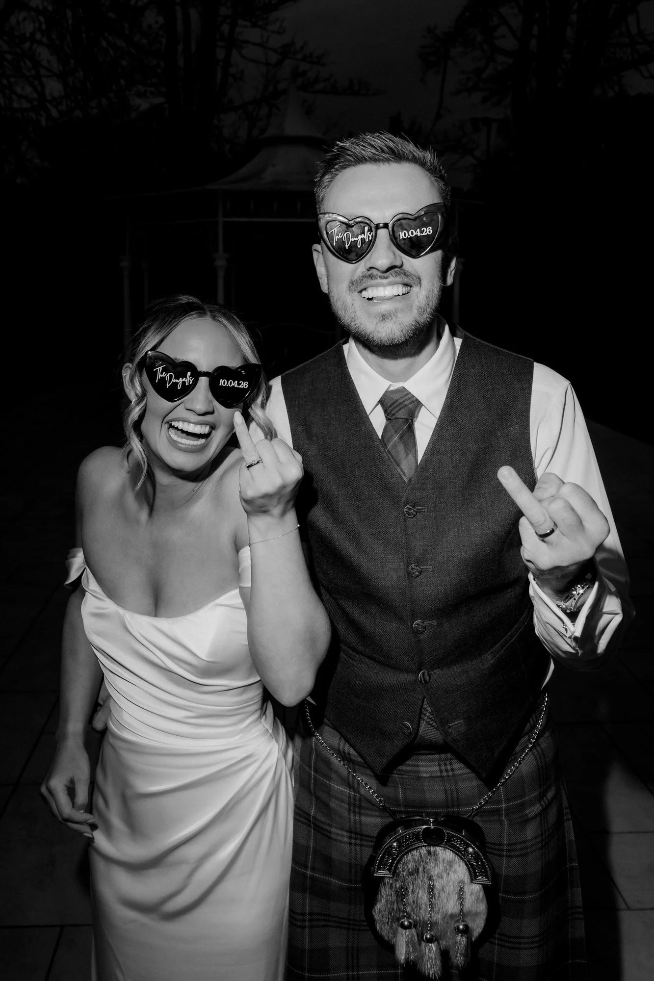 Elle and Adam laughing and showing their wedding rings to the camera