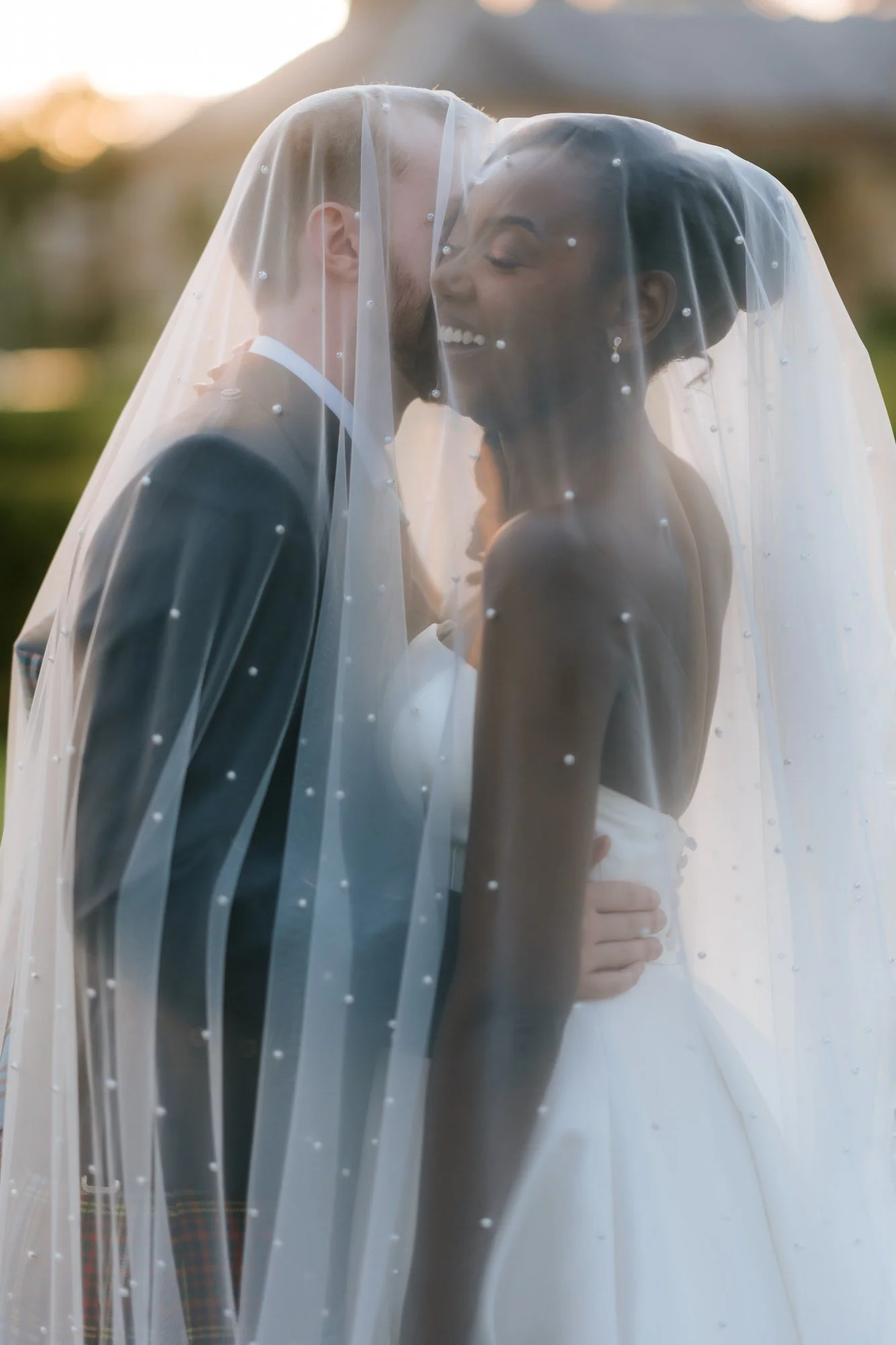 Kuda laughing beneath her veil with Jamie in the evening light.