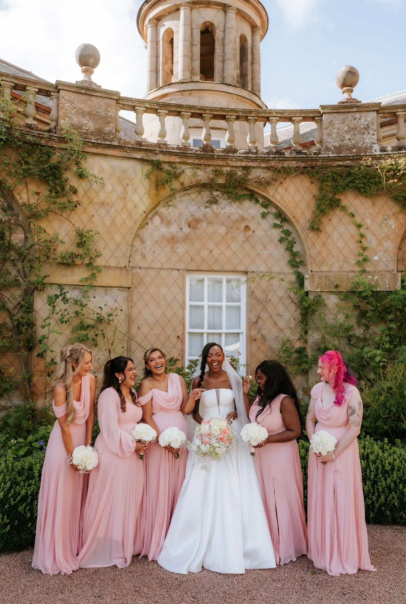 The bridesmaids sharing a laugh with Kuda in the garden.
