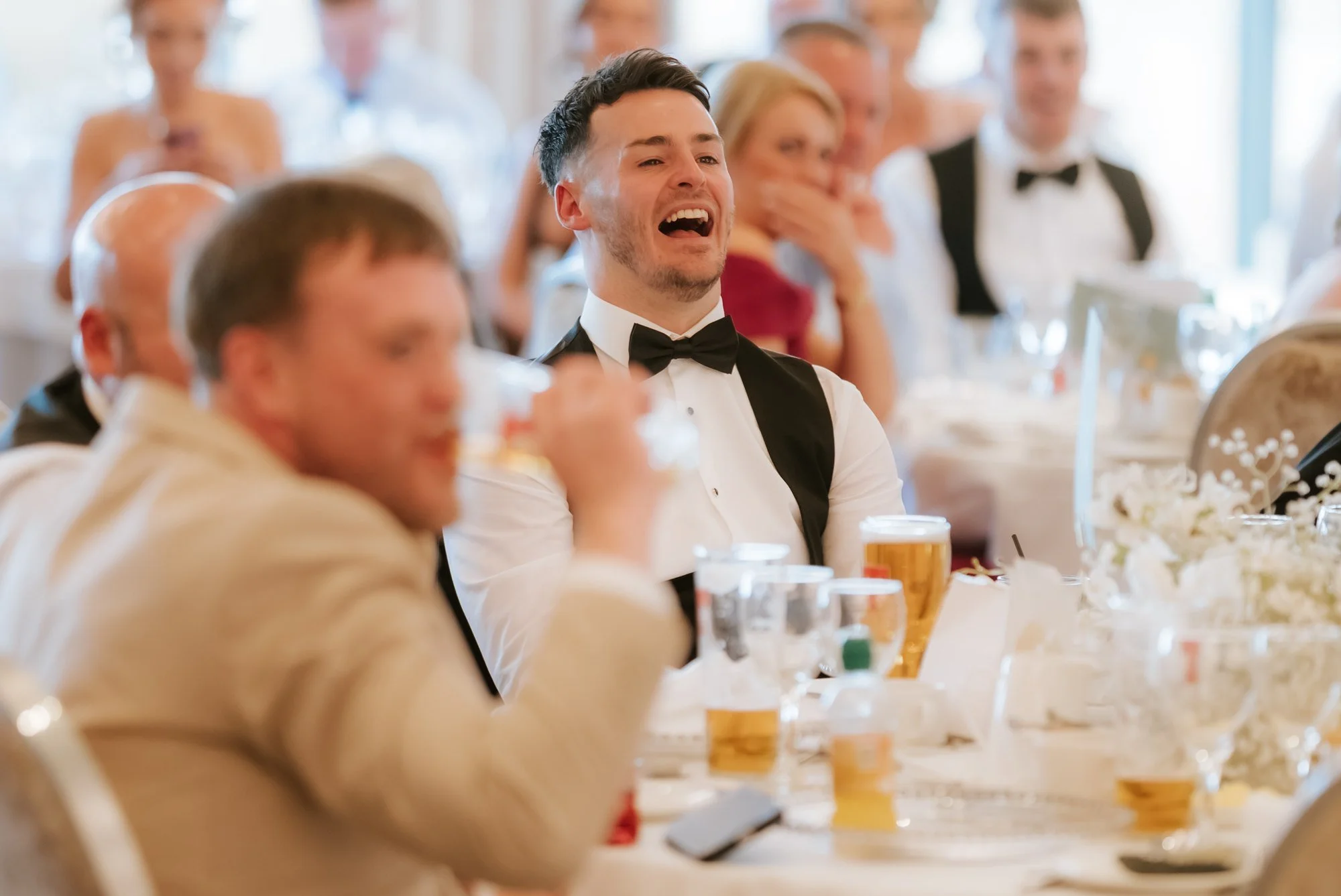 Guests laughing together during the reception speeches.