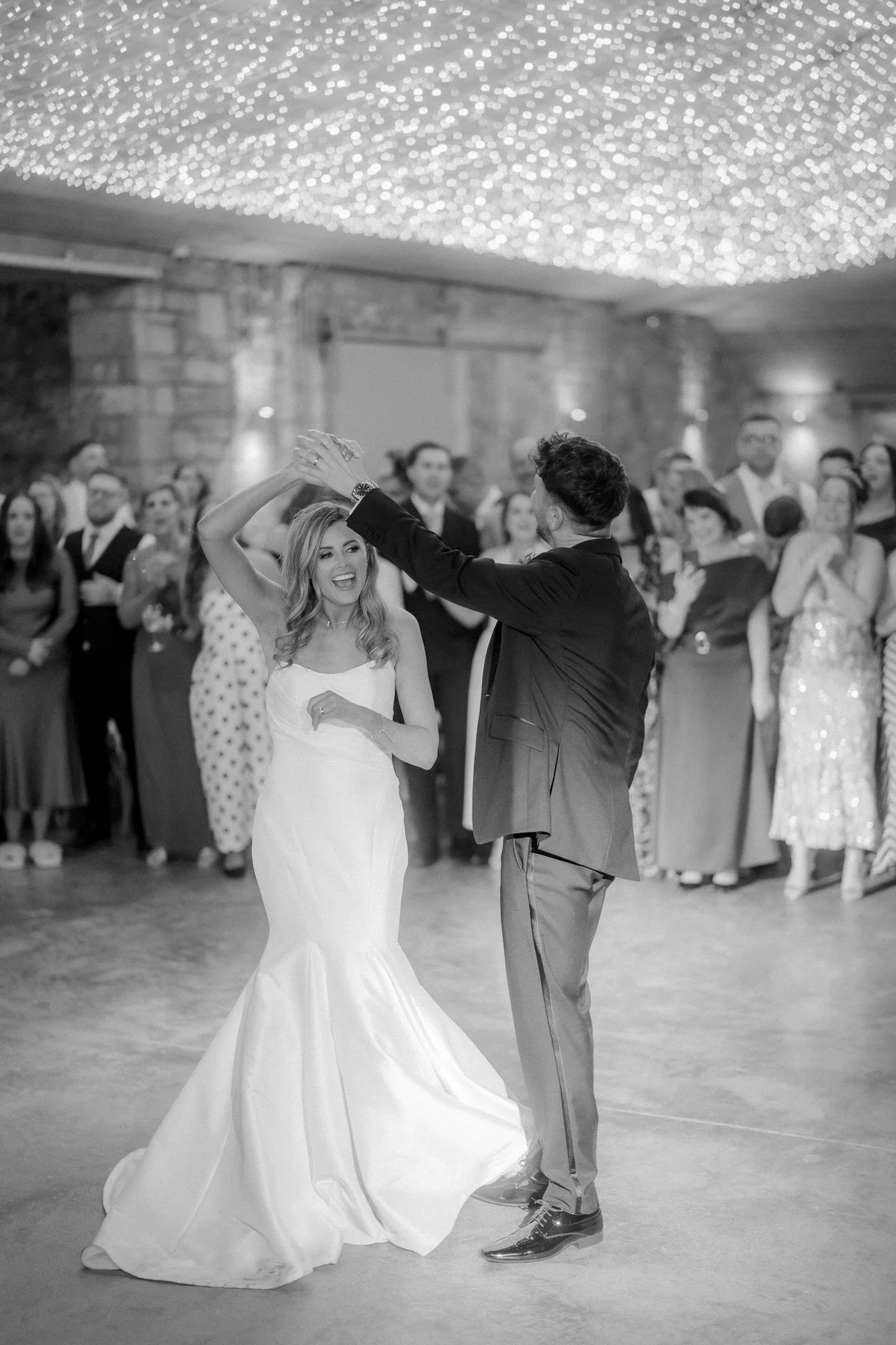 Black-and-white photograph of a twirl on the wedding dance floor