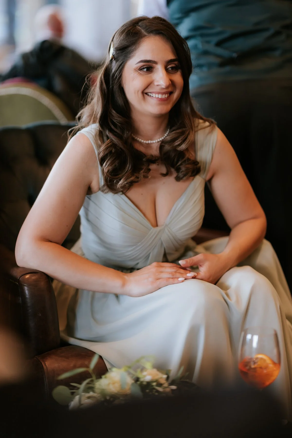 A bridesmaid smiling while sitting with other guests at Cameron House.