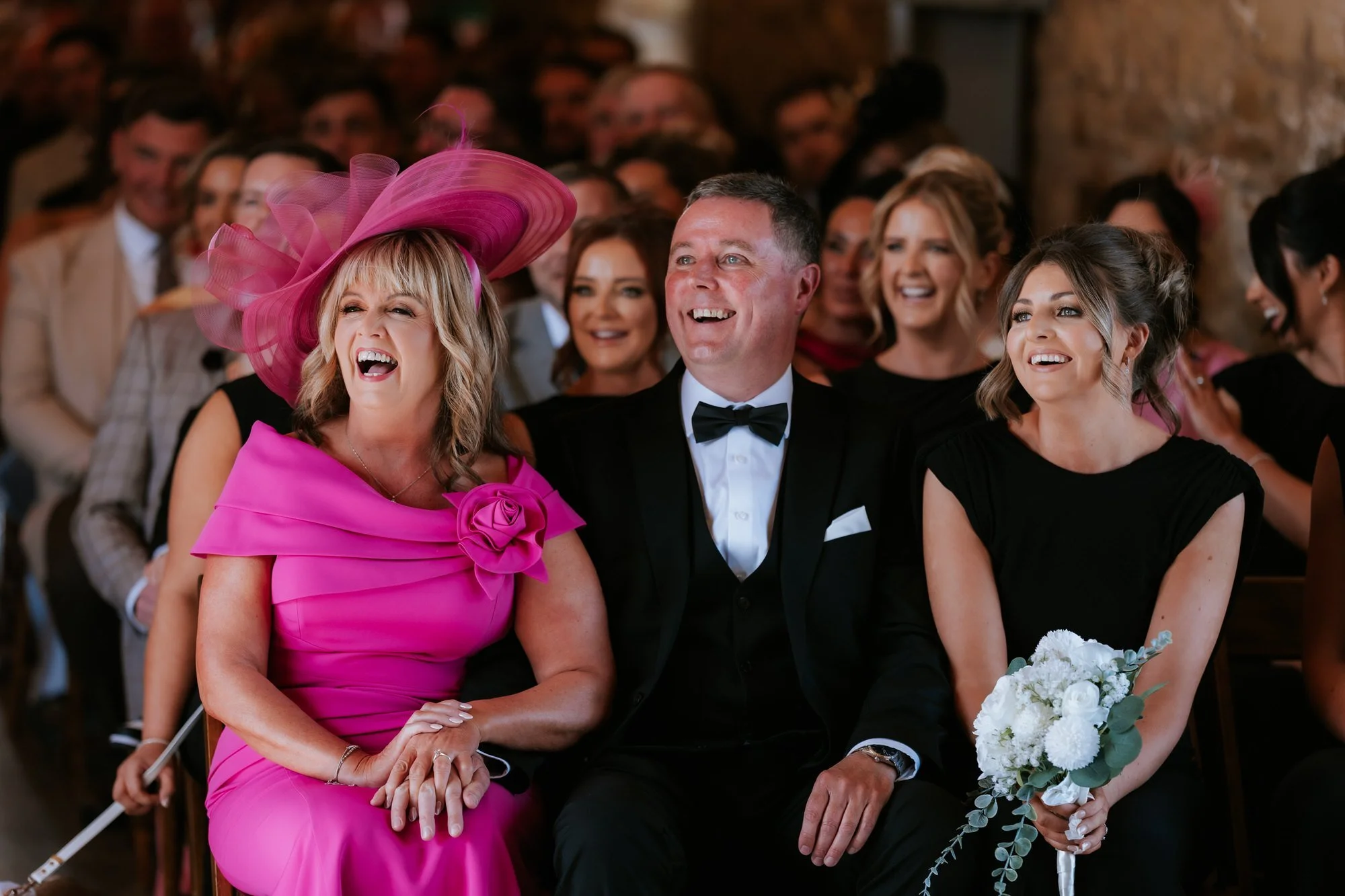Guests in the front row laughing during the ceremony