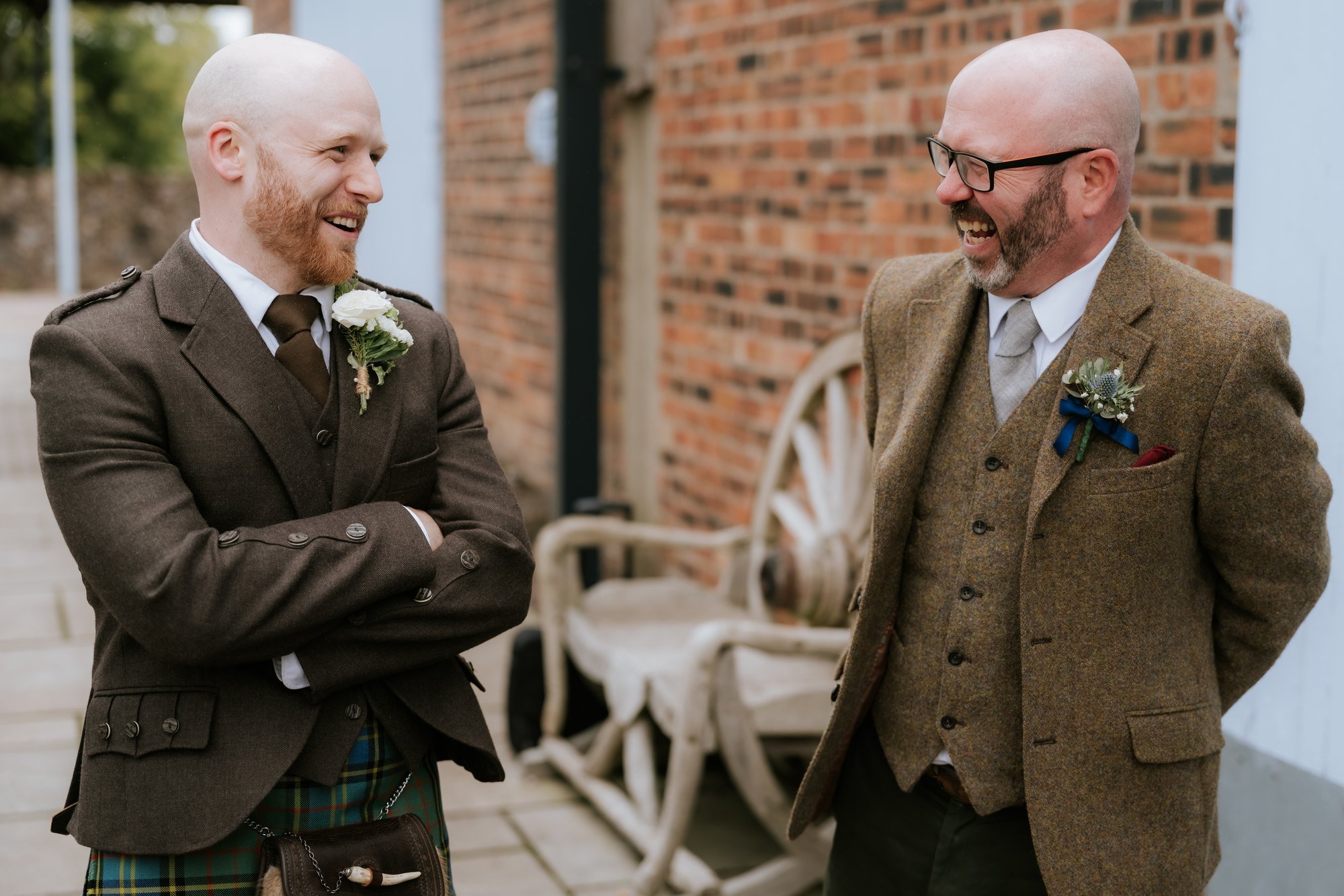 Two wedding guests laughing together outside the reception.