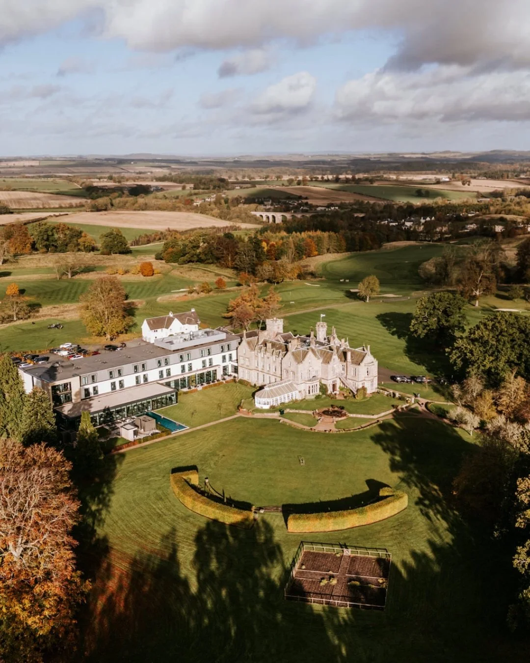 Aerial view of SCHLOSS Roxburghe, its gardens and the surrounding countryside in autumn.