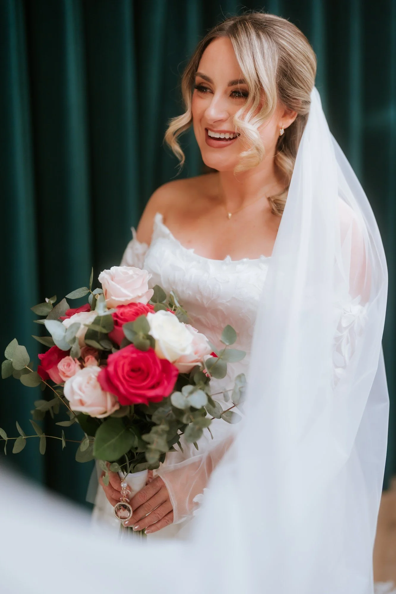 Ciara holding her bouquet beside the window.