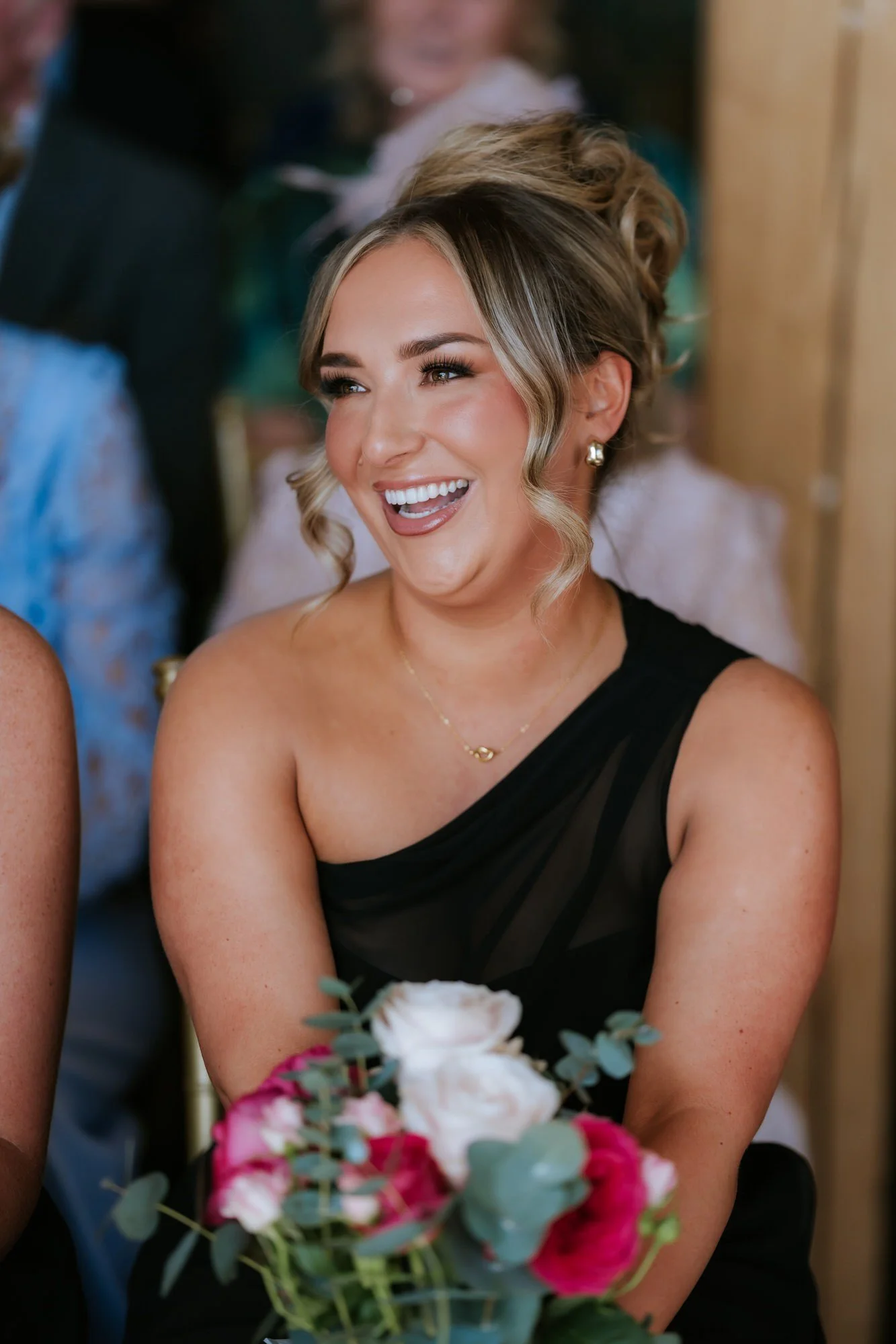 A bridesmaid laughing during the wedding ceremony.