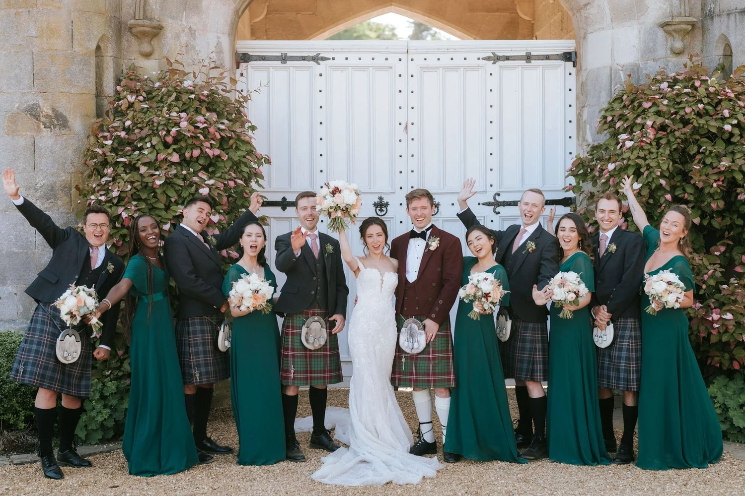 Kim, Kenneth and their wedding party cheering together outside the castle.