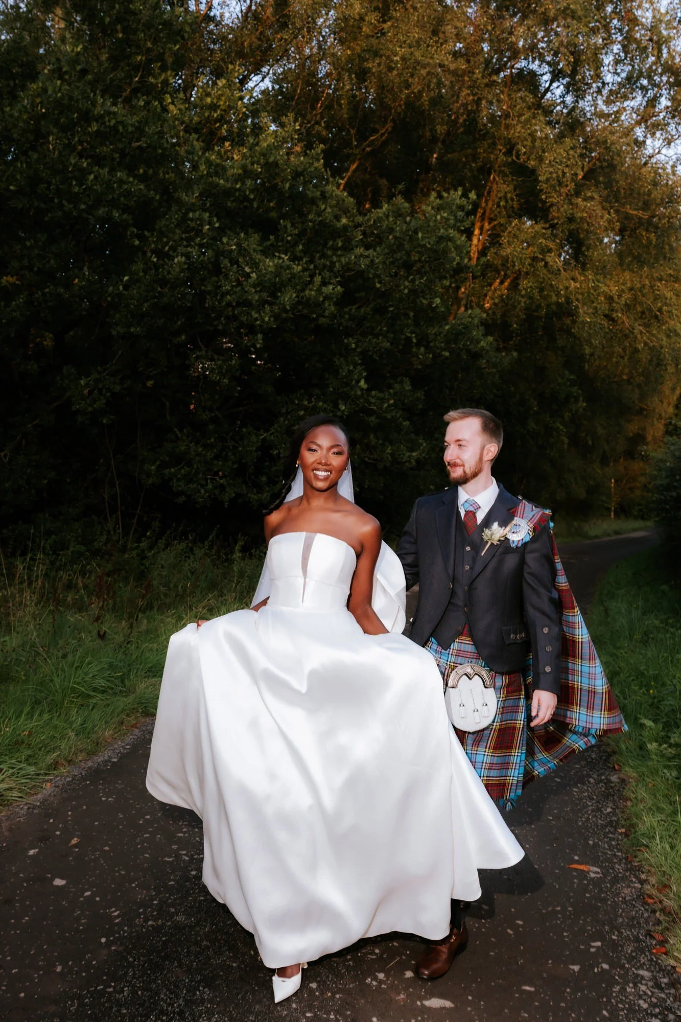 Kuda and Jamie laughing on a tree-lined path.