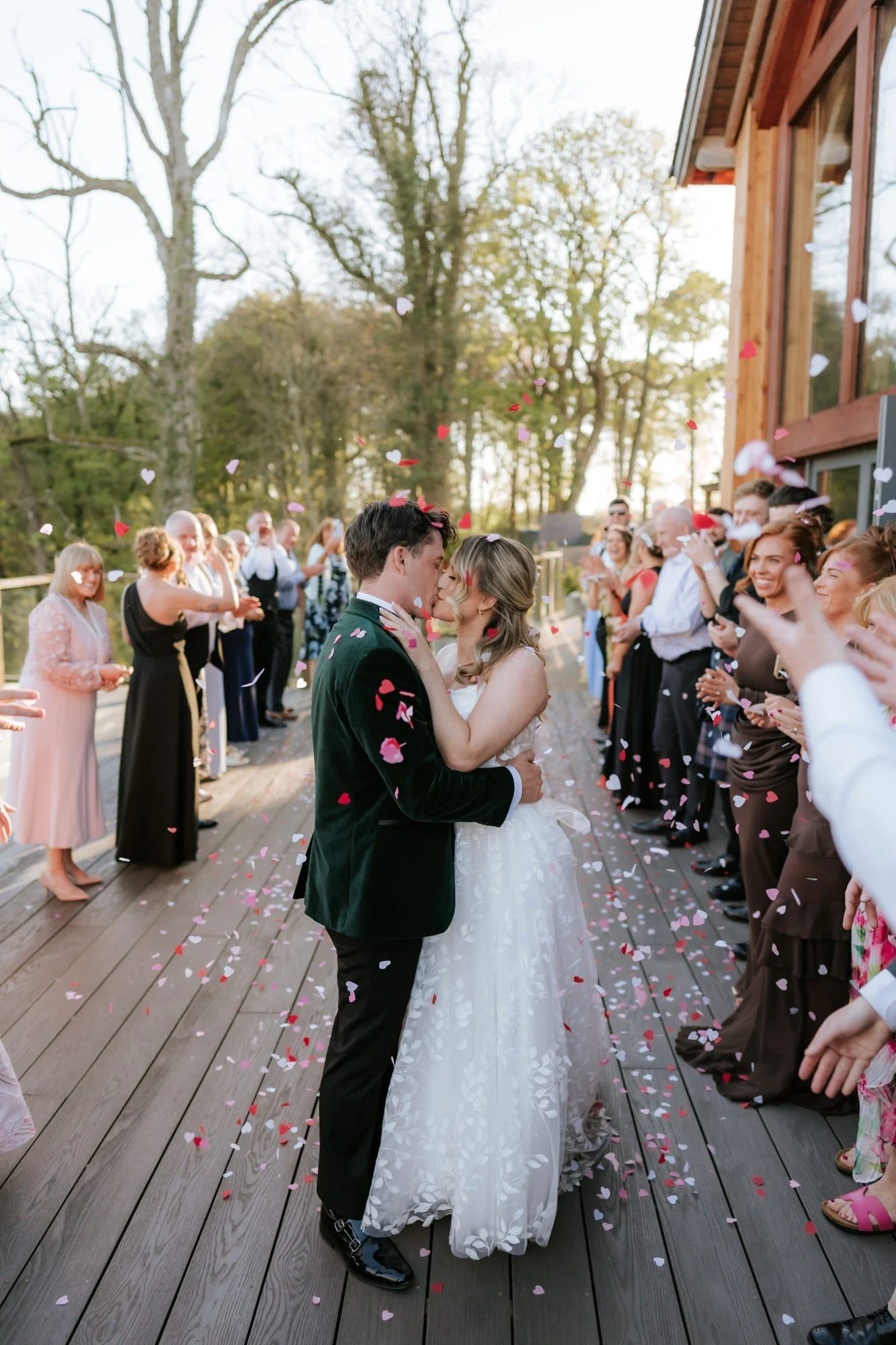 Ciara and Jonathon kissing beneath confetti on the decking after dinner.