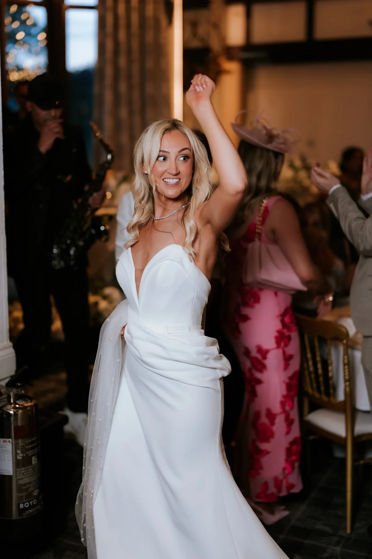 Lauren dancing with her hand in the air among her wedding guests.