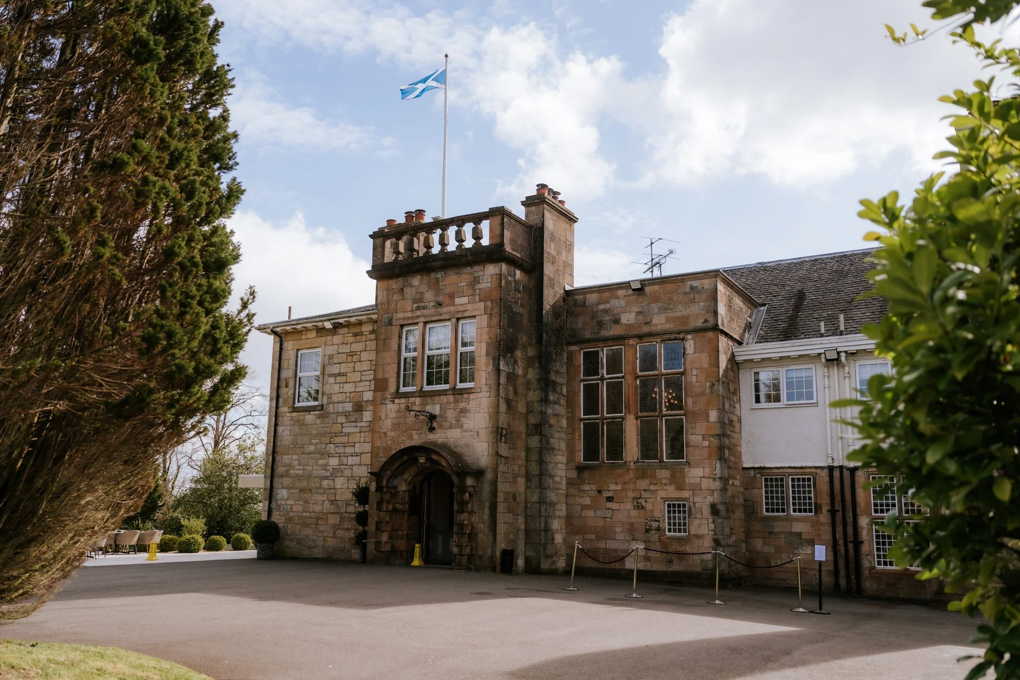 Dalmeny Park House Hotel framed by trees beneath a blue sky