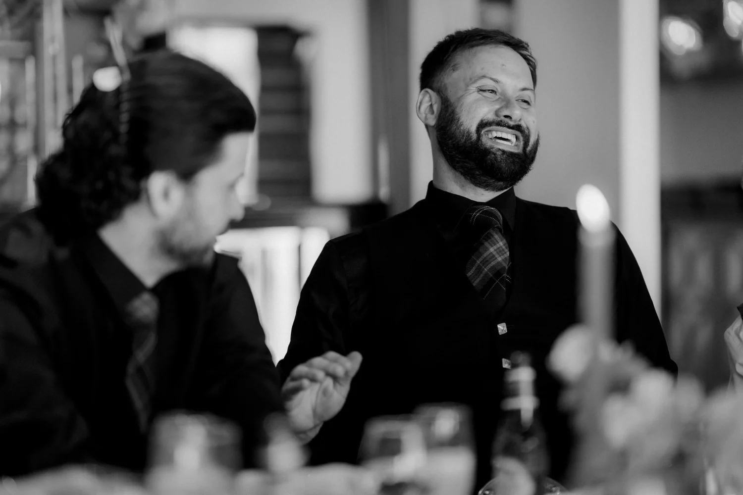Two guests laughing at their reception table.