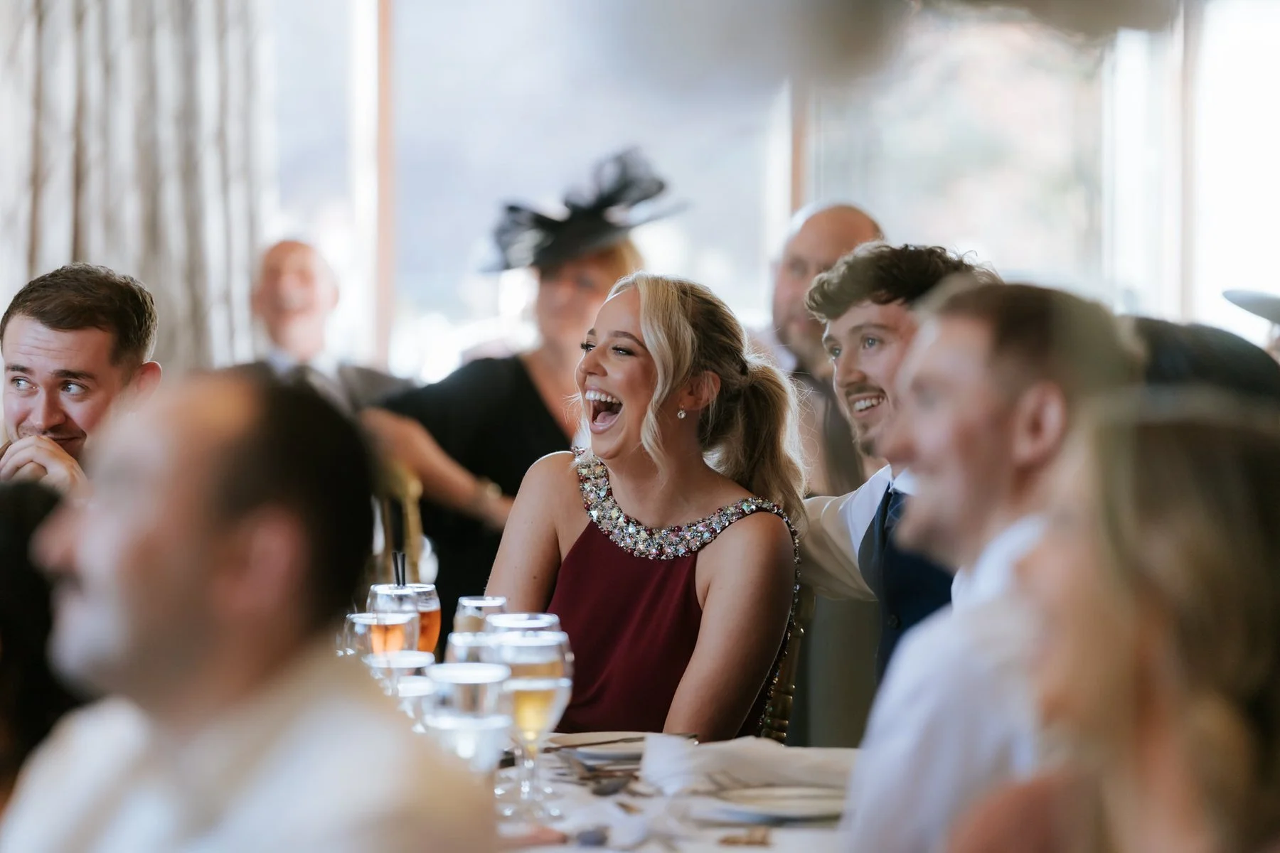 Guests laughing and reacting to a wedding speech.
