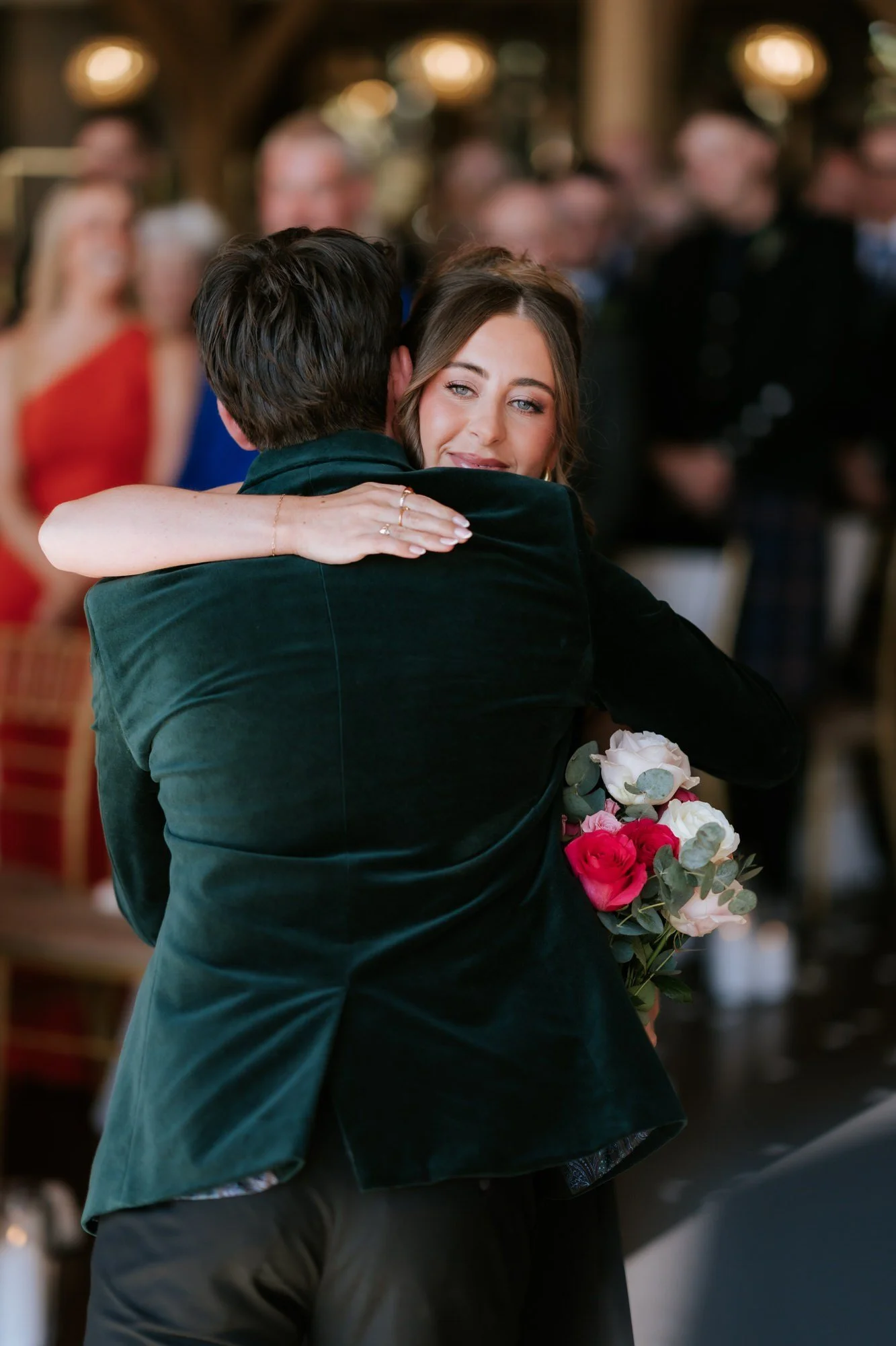 A bridesmaid giving Jonathon a hug as she reaches the aisle.