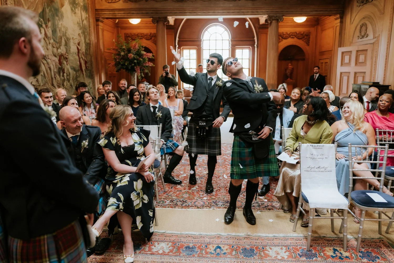 The flower men scattering petals along the ceremony aisle.