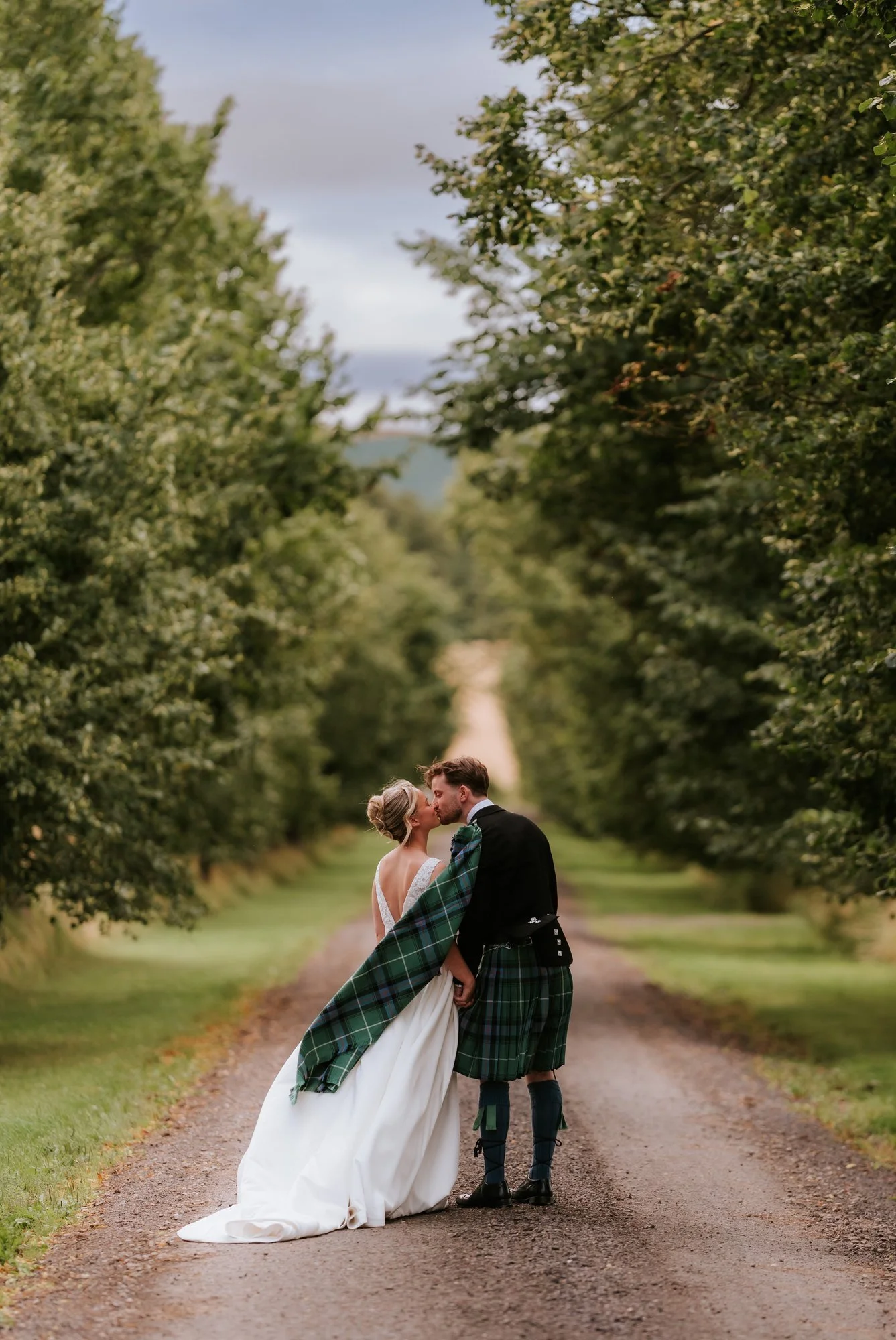 Lilian and Luke embracing on a quiet tree-lined lane at Rossie on the Earn.
