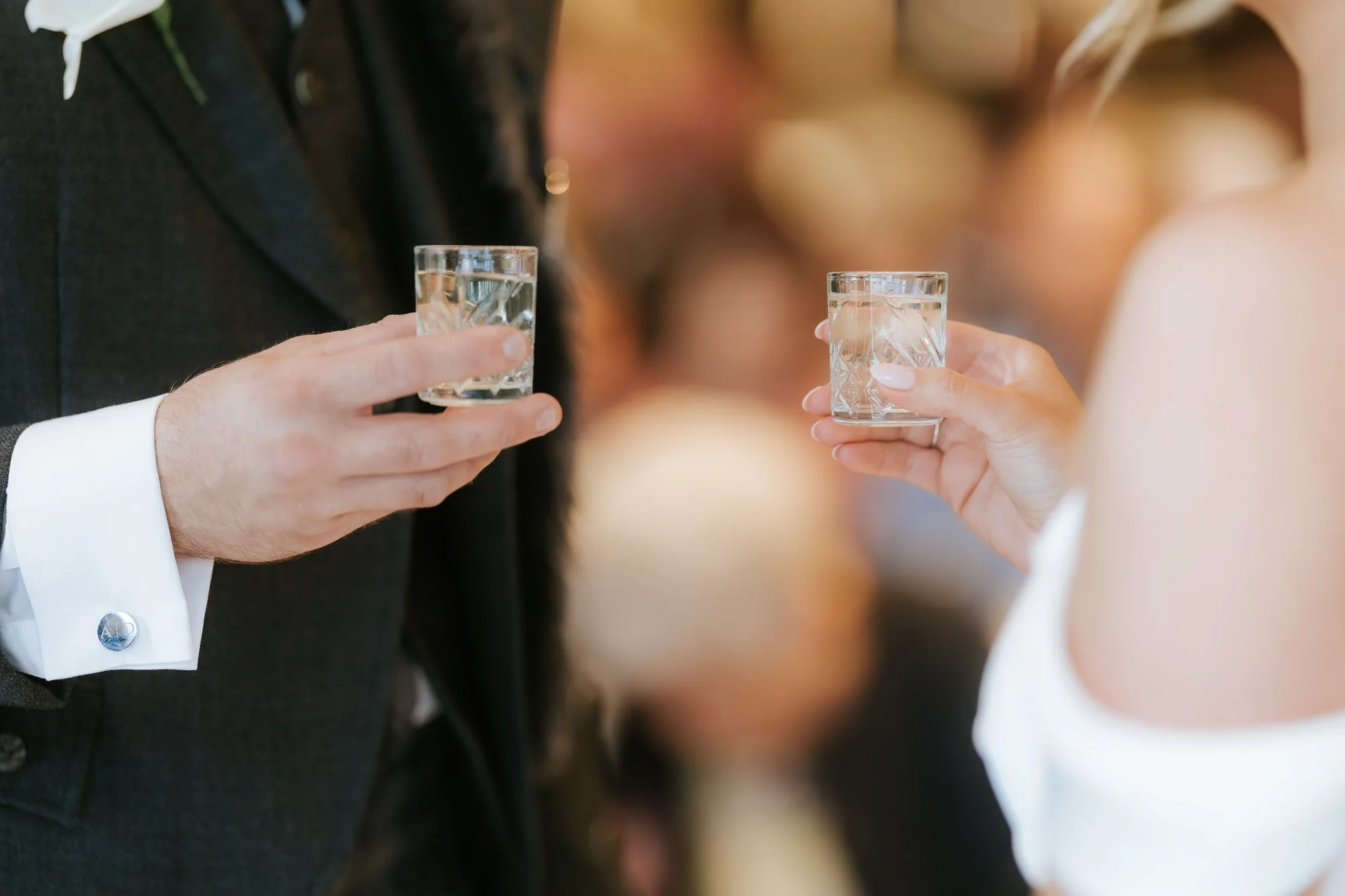 Elle and Adam holding shot glasses during their wedding ceremony