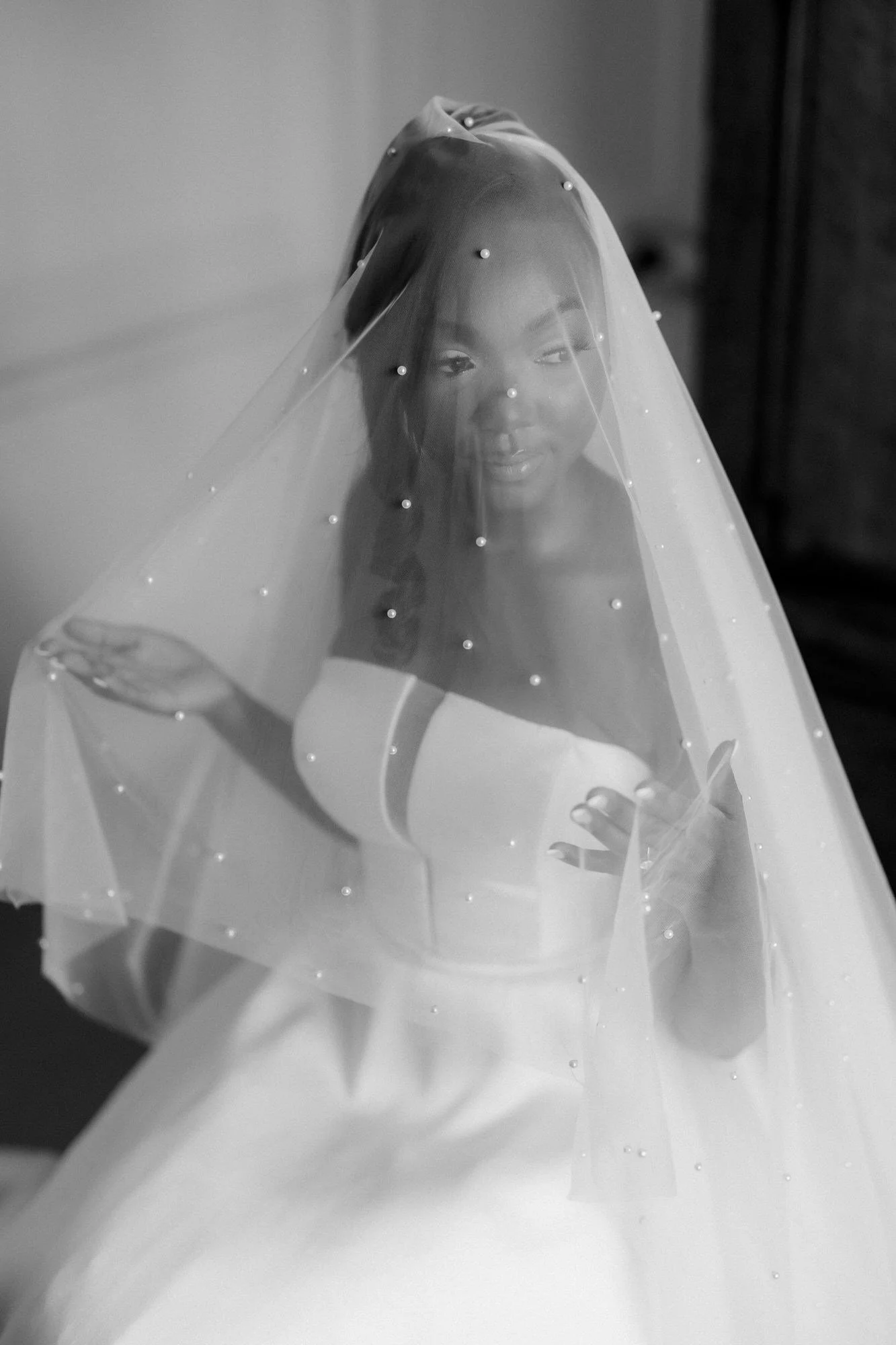 A black and white portrait of Kuda wearing her pearl-detailed veil.