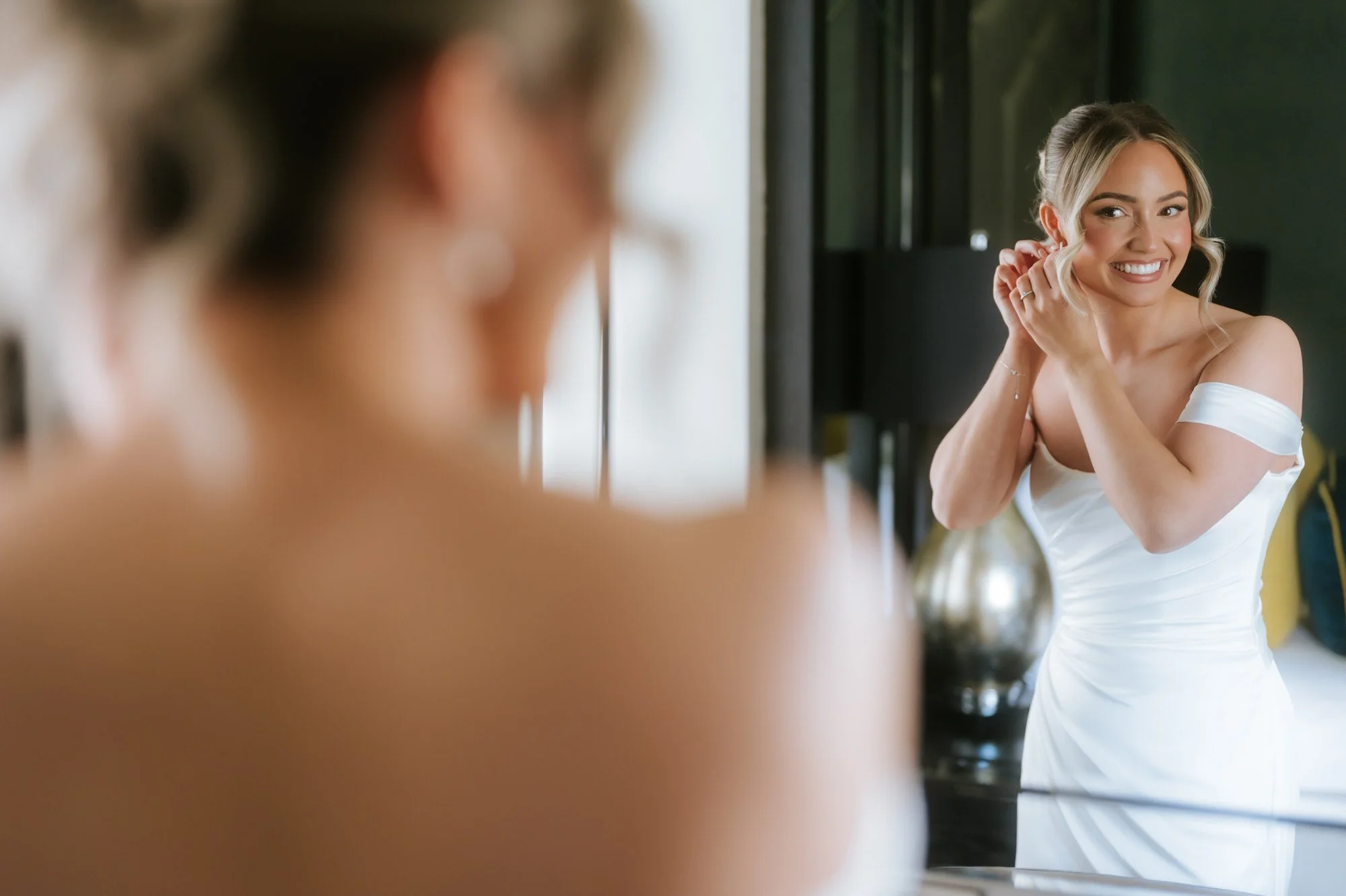 Elle checking her earrings in a mirror