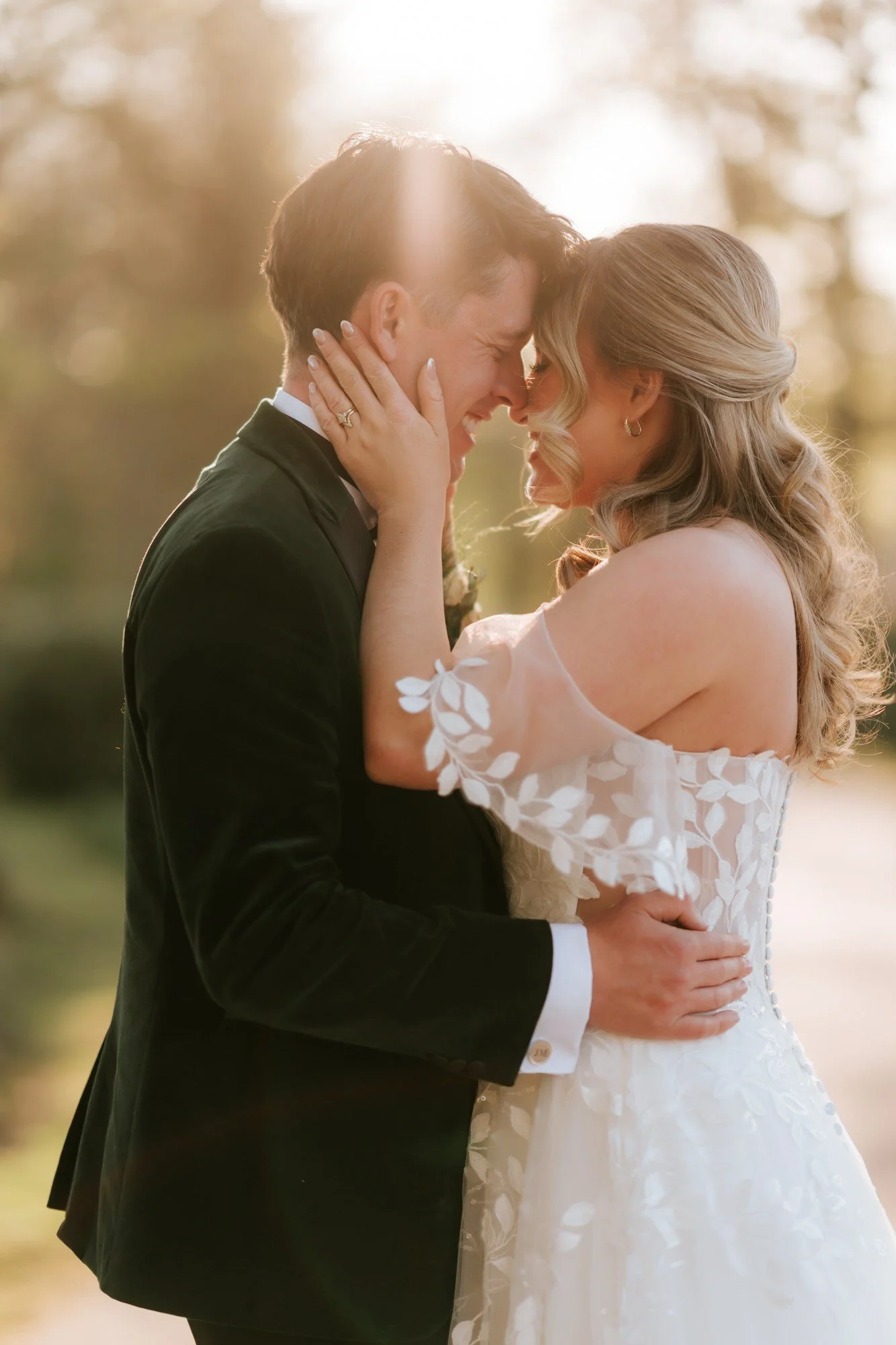 Ciara holding Jonathon’s face as they laugh in the golden evening light.