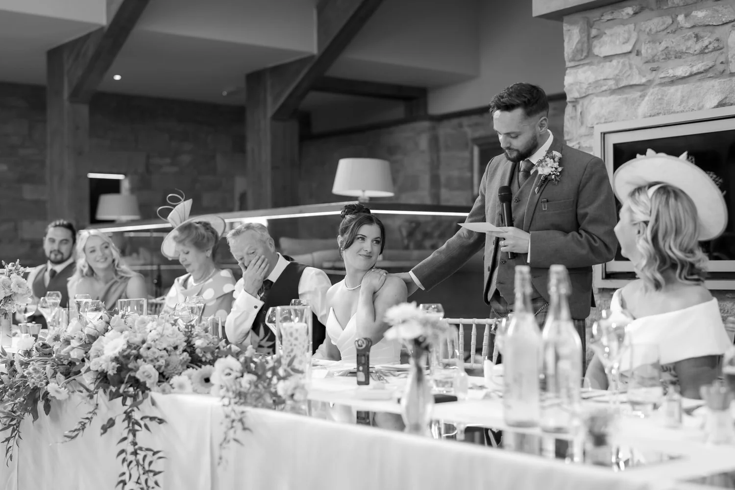 Black-and-white photograph of Dougie giving his wedding speech beside Lois.
