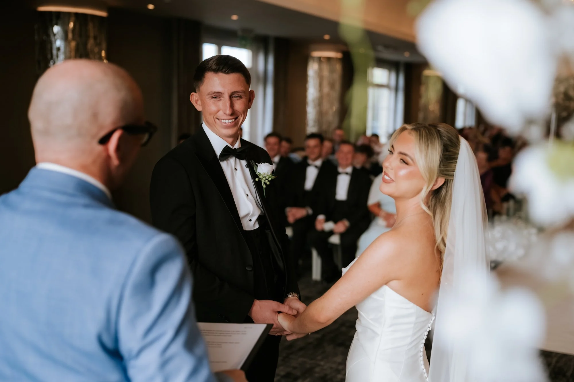 Taylor and Aiden smiling at each other during their wedding ceremony.