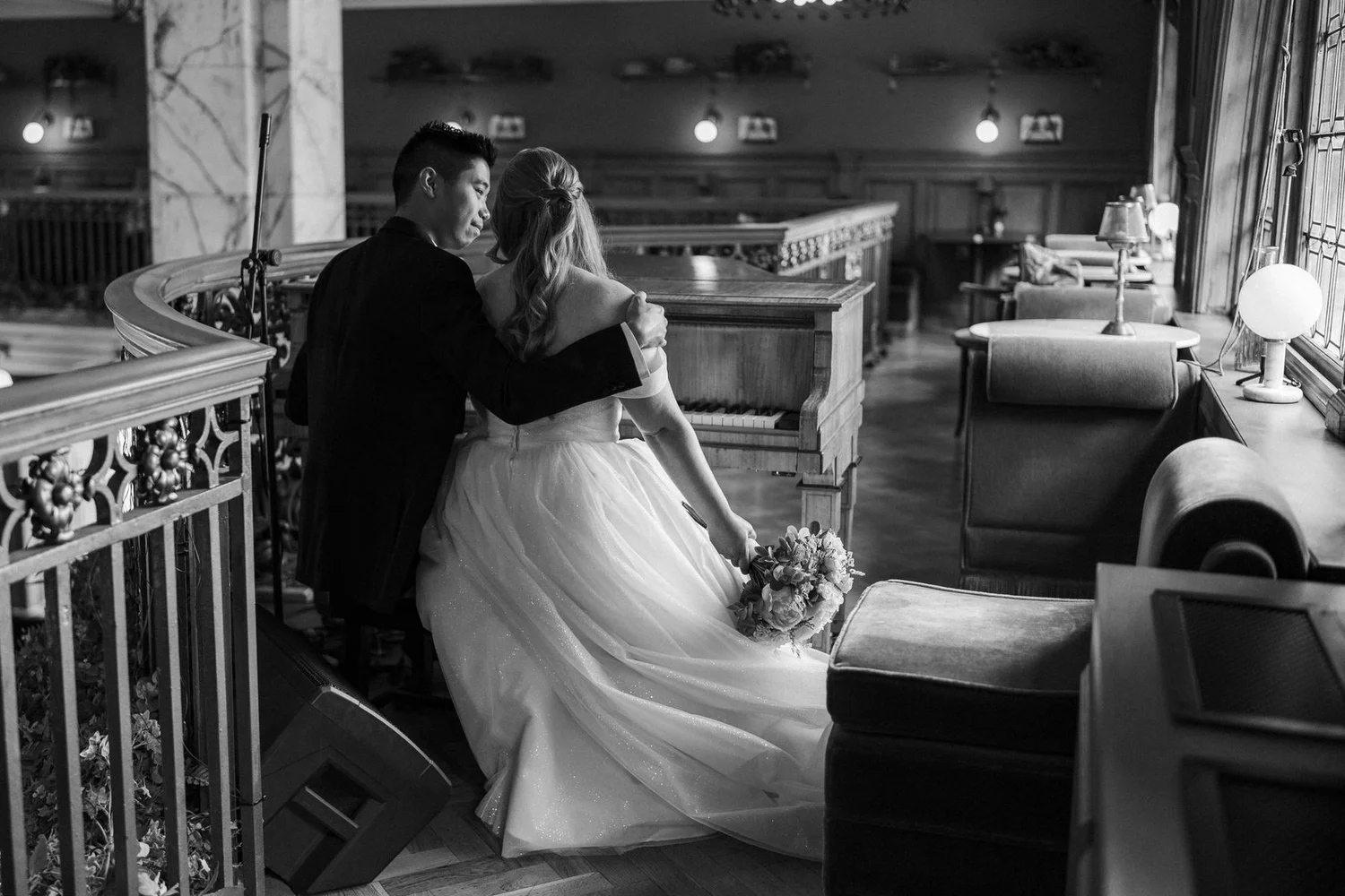 Allie and Carl embracing beside the curved balustrade inside The Scotsman Hotel.