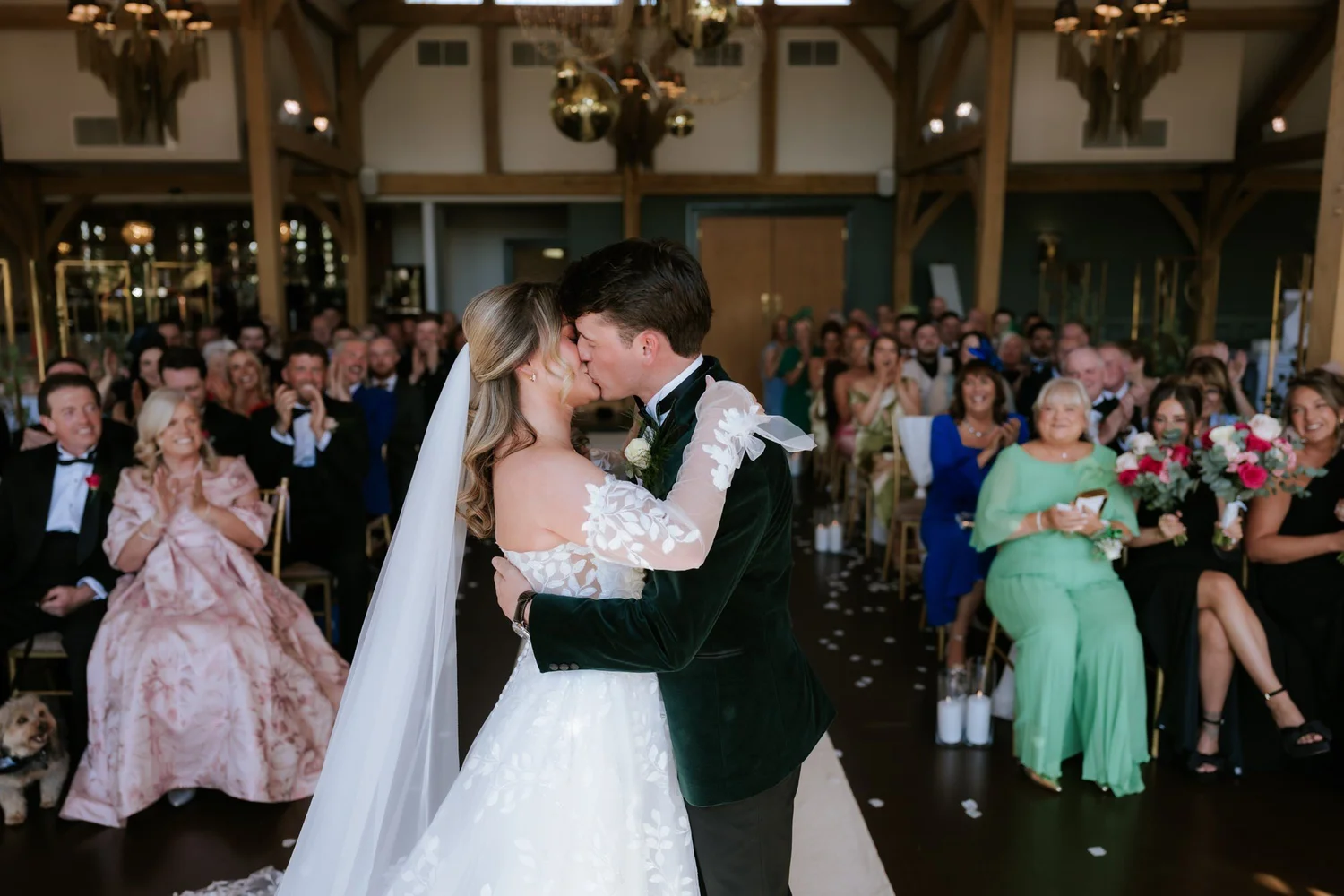 Ciara and Jonathon sharing their first kiss as their guests watch.