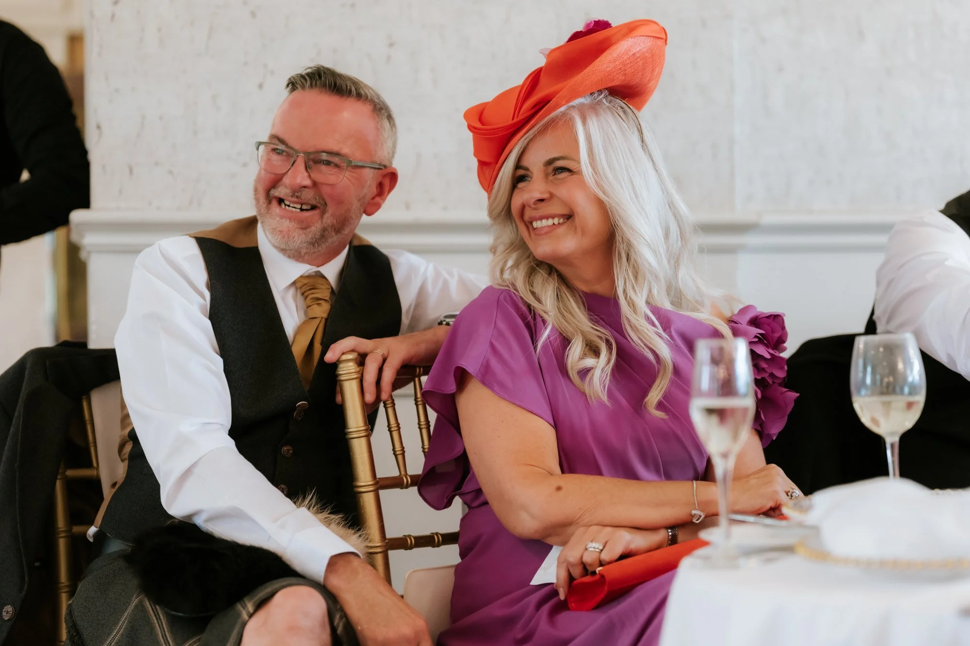 Two wedding guests smiling together at their reception table at Glenbervie House.