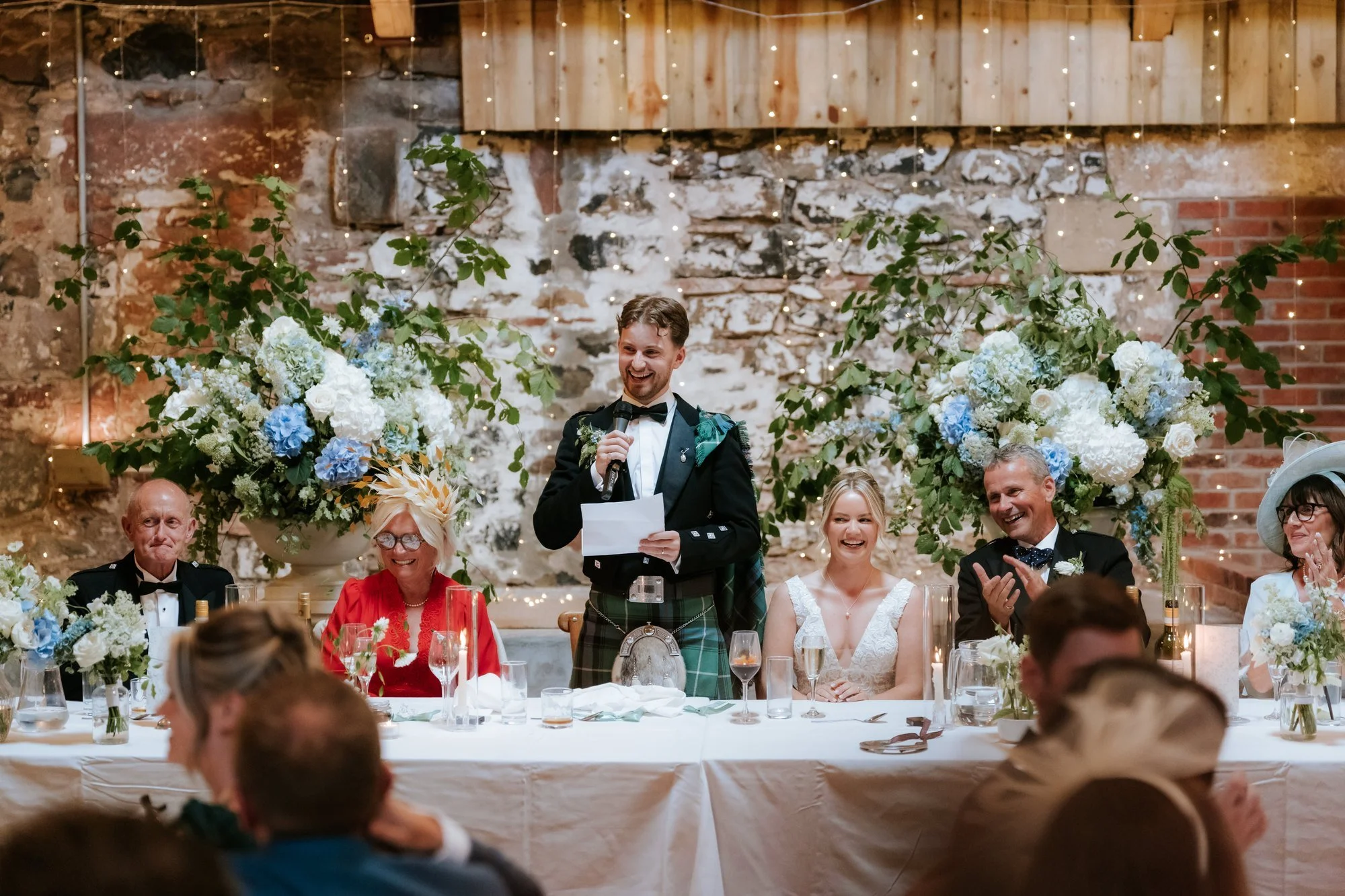 A speech at the top table beneath the flowers in the rustic byre at Rossie on the Earn.